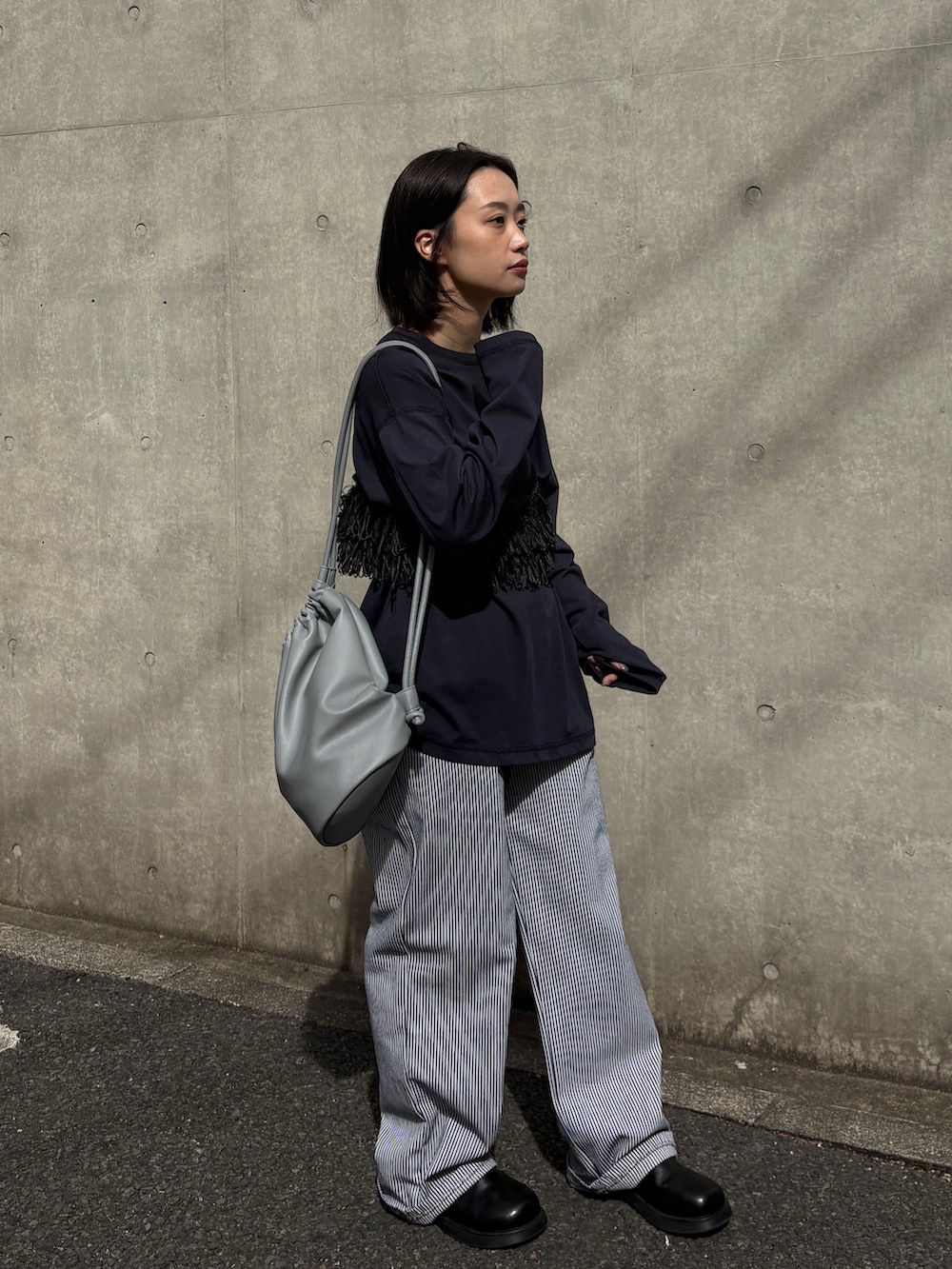 ホワイト系のデニムパンツ、ブラック系のその他シューズ、ブルー系のTシャツ/カットソーを着用したレディースの春コーディネートの3枚目の写真