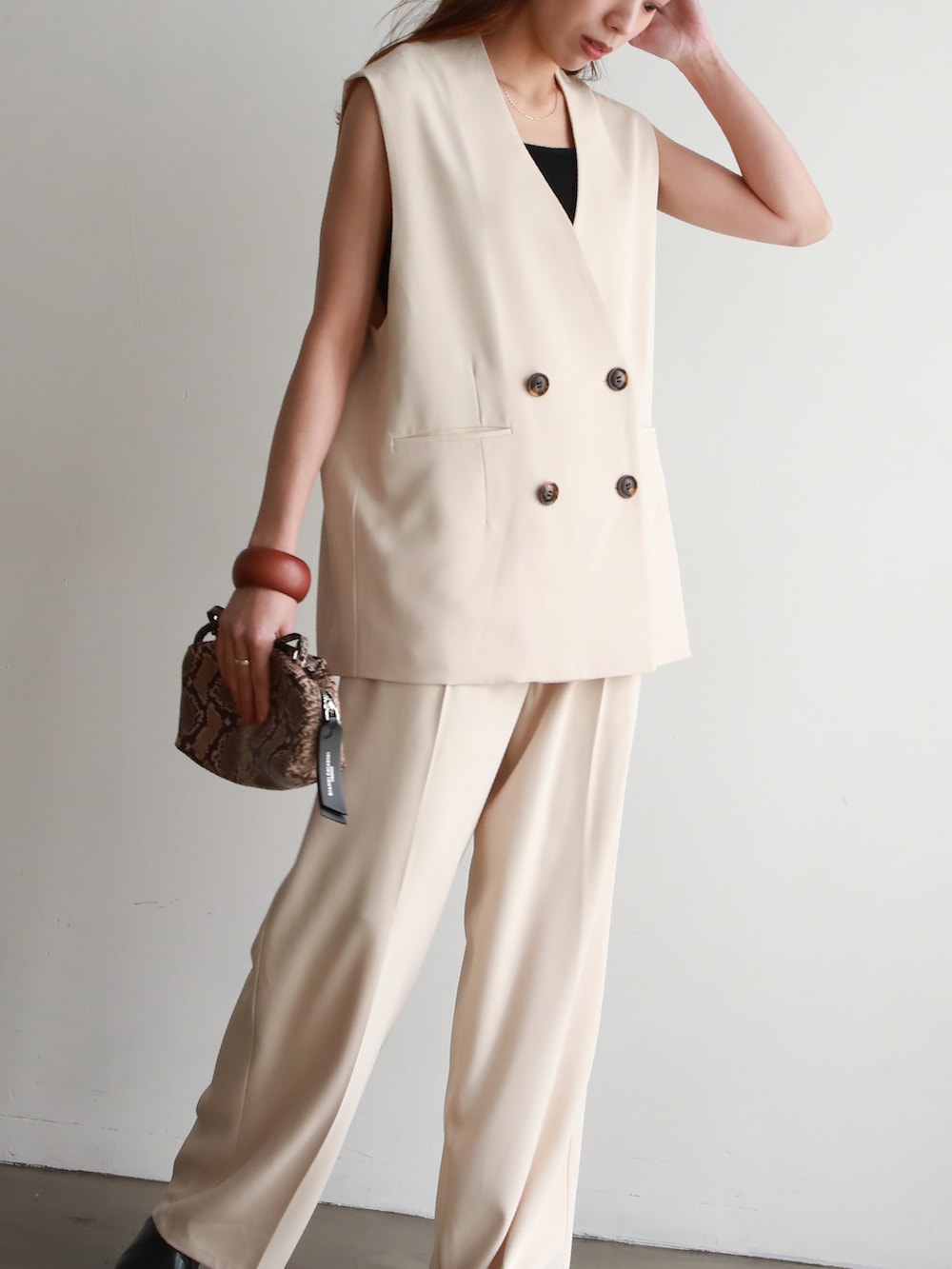 ホワイト系のセットアップ、その他のショルダーバッグ、ブラック系のサンダルを着用したレディースの春コーディネートの2枚目の写真