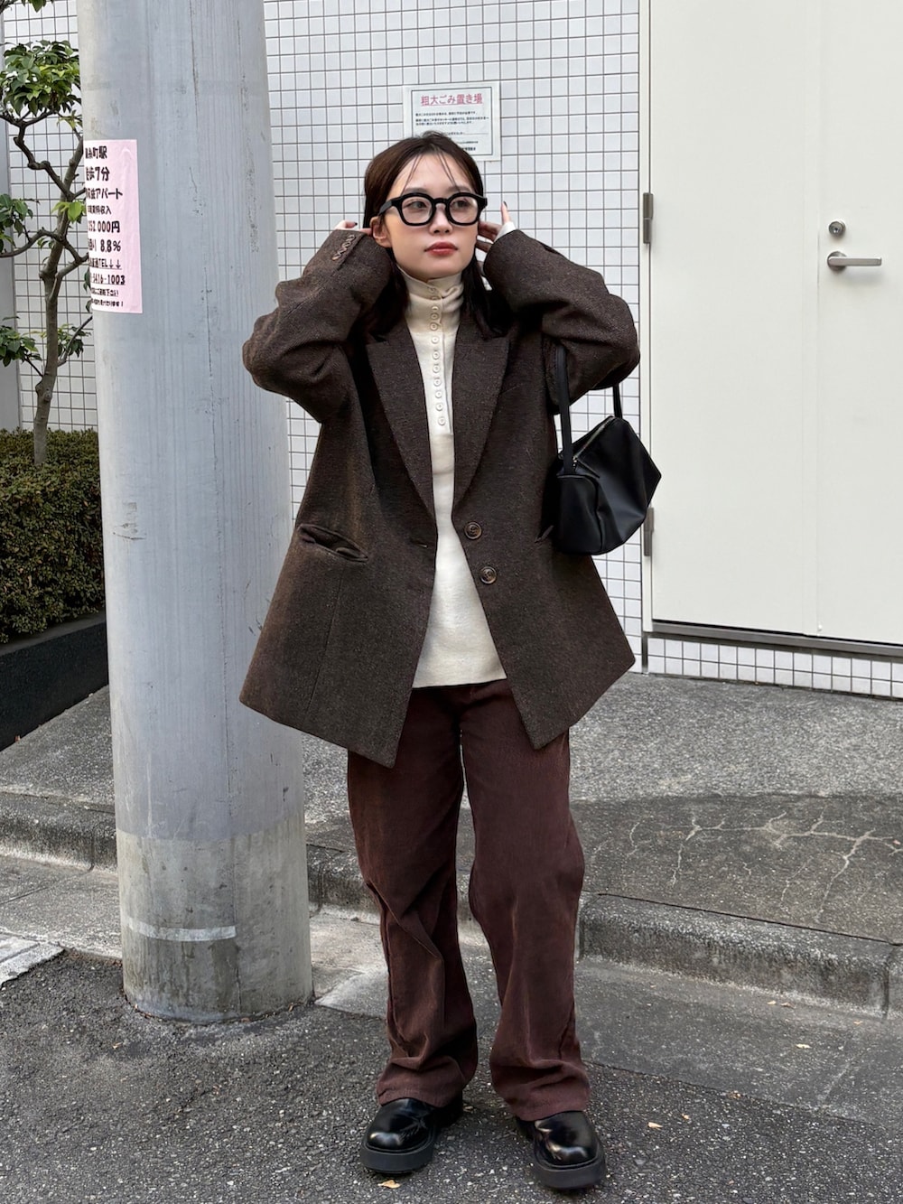 ブラウン系のテーラードジャケット、ブラック系のショルダーバッグ、ブラウン系のその他パンツを着用したレディースの冬コーディネートの2枚目の写真