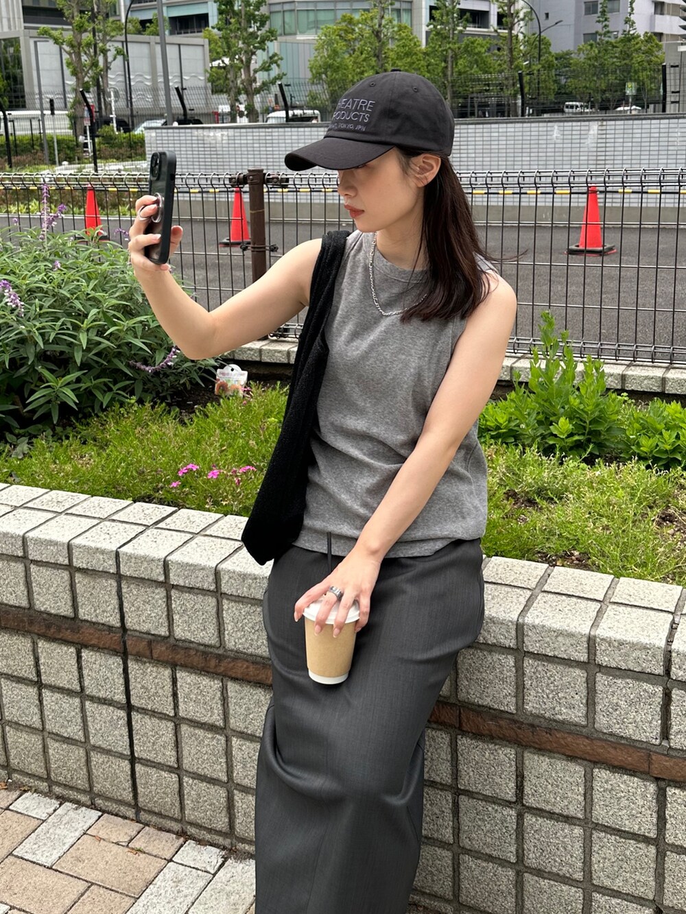 グレー系のタンクトップ、グレー系のスカート、ブラック系のトートバッグを着用したレディースの夏コーディネートの4枚目の写真