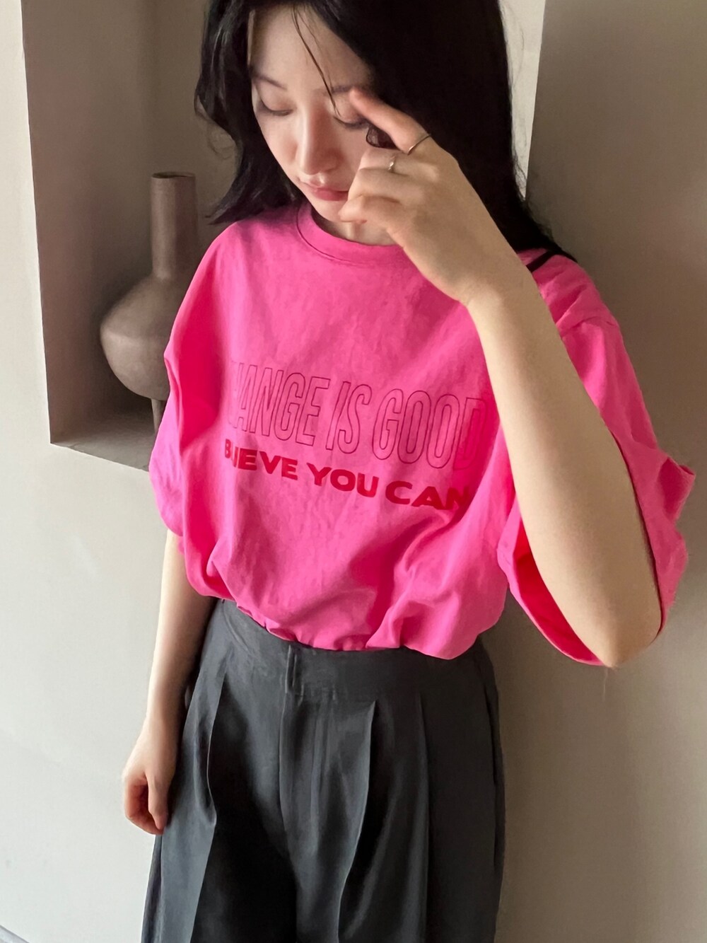 グレー系のスラックス、ピンク系のTシャツ/カットソー、ブラック系のスリッポンを着用したレディースの夏コーディネートの4枚目の写真