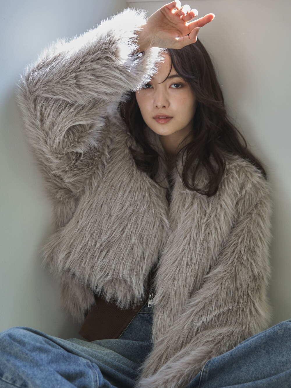 ベージュ系のその他アウター、ブラウン系のニット/セーター、ブルー系のデニムパンツを着用したレディースの冬コーディネートの5枚目の写真