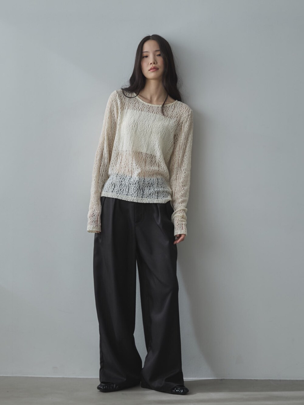 ホワイト系のキャミソール、ホワイト系のTシャツ/カットソー、ブラック系のスラックスを着用したレディースの冬コーディネートの3枚目の写真