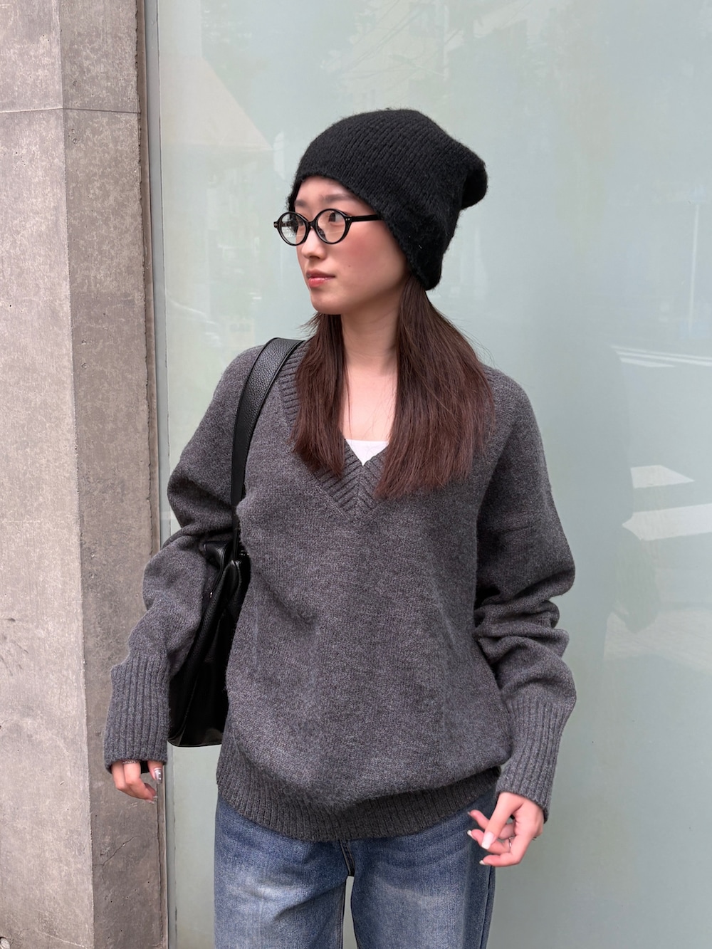 ブルー系のデニムパンツ、ブラック系のローファー、ブラック系のショルダーバッグを着用したレディースの秋コーディネートの3枚目の写真