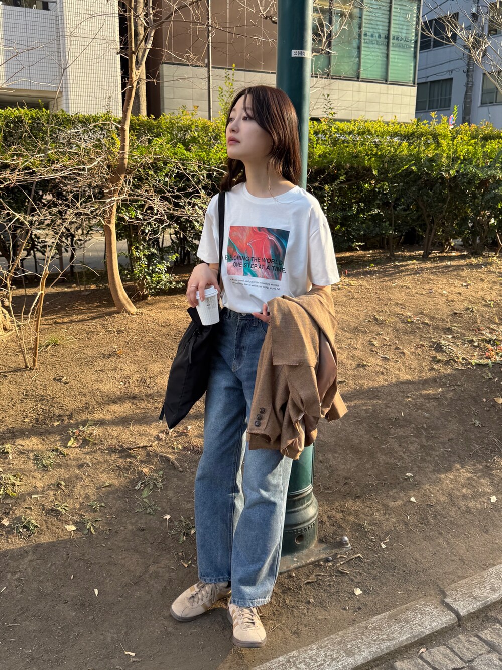 ブラウン系のテーラードジャケット、ホワイト系のTシャツ/カットソー、ブルー系のデニムパンツを着用したレディースの春コーディネートの3枚目の写真