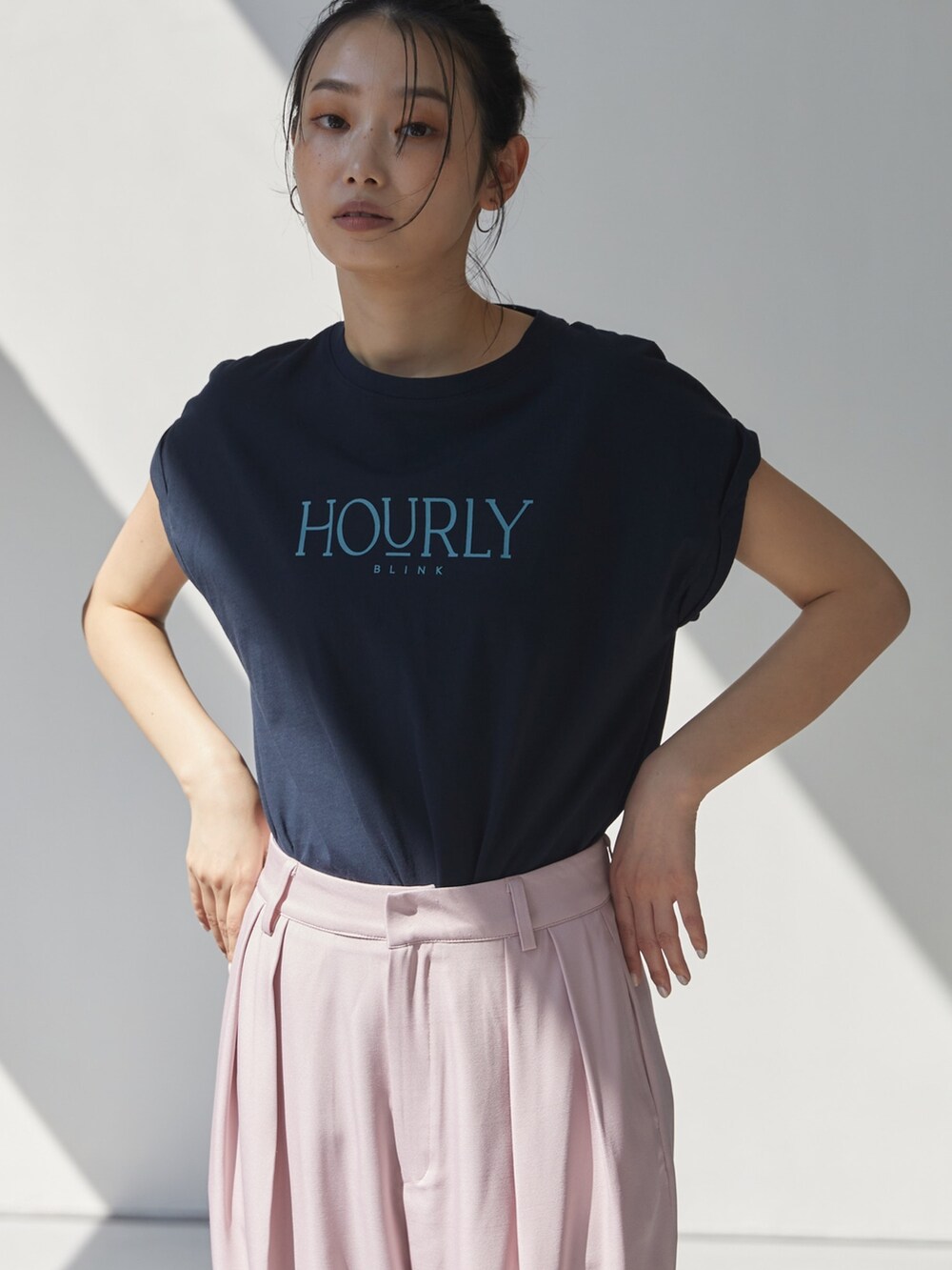 ピンク系のスラックス、ブルー系のTシャツ/カットソー、ブラック系のサンダルを着用したレディースの夏コーディネートの3枚目の写真