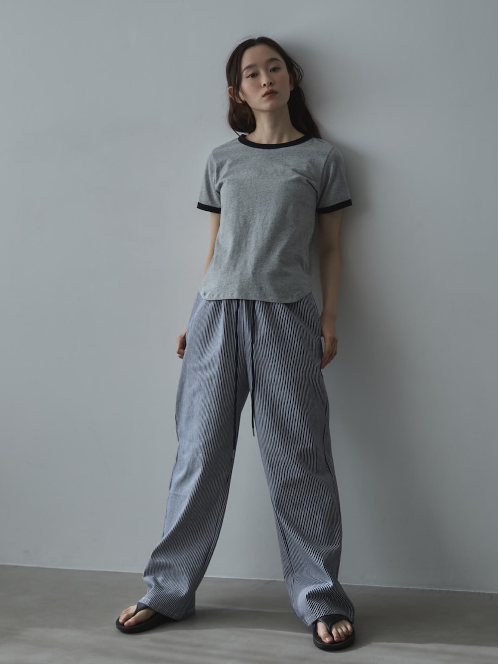 グレー系のTシャツ/カットソー、ホワイト系のデニムパンツ、ブラック系のサンダルを着用したレディースの夏コーディネートの3枚目の写真