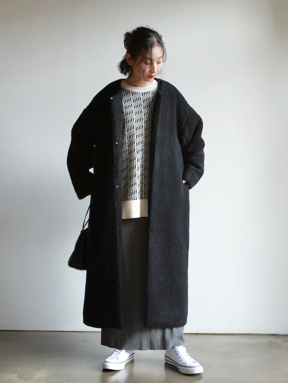 グレー系のスカート、ブルー系のTシャツ/カットソー、ブラック系のニット/セーターを着用したレディースの冬コーディネートの2枚目の写真