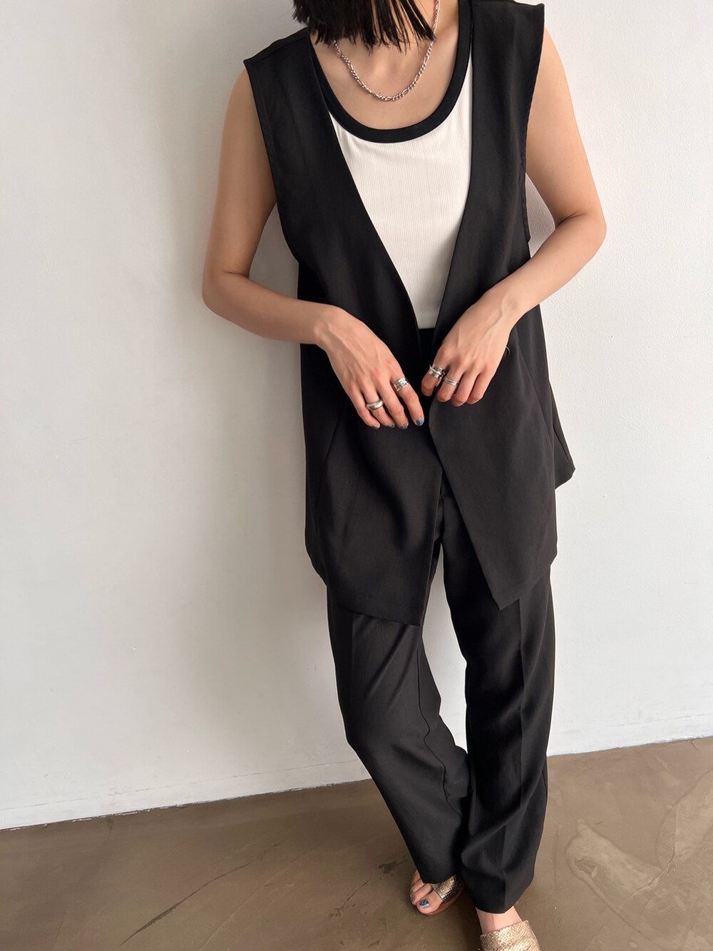 ホワイト系のタンクトップ、ブラック系のセットアップ、その他のサンダルを着用したレディースの春コーディネートの2枚目の写真