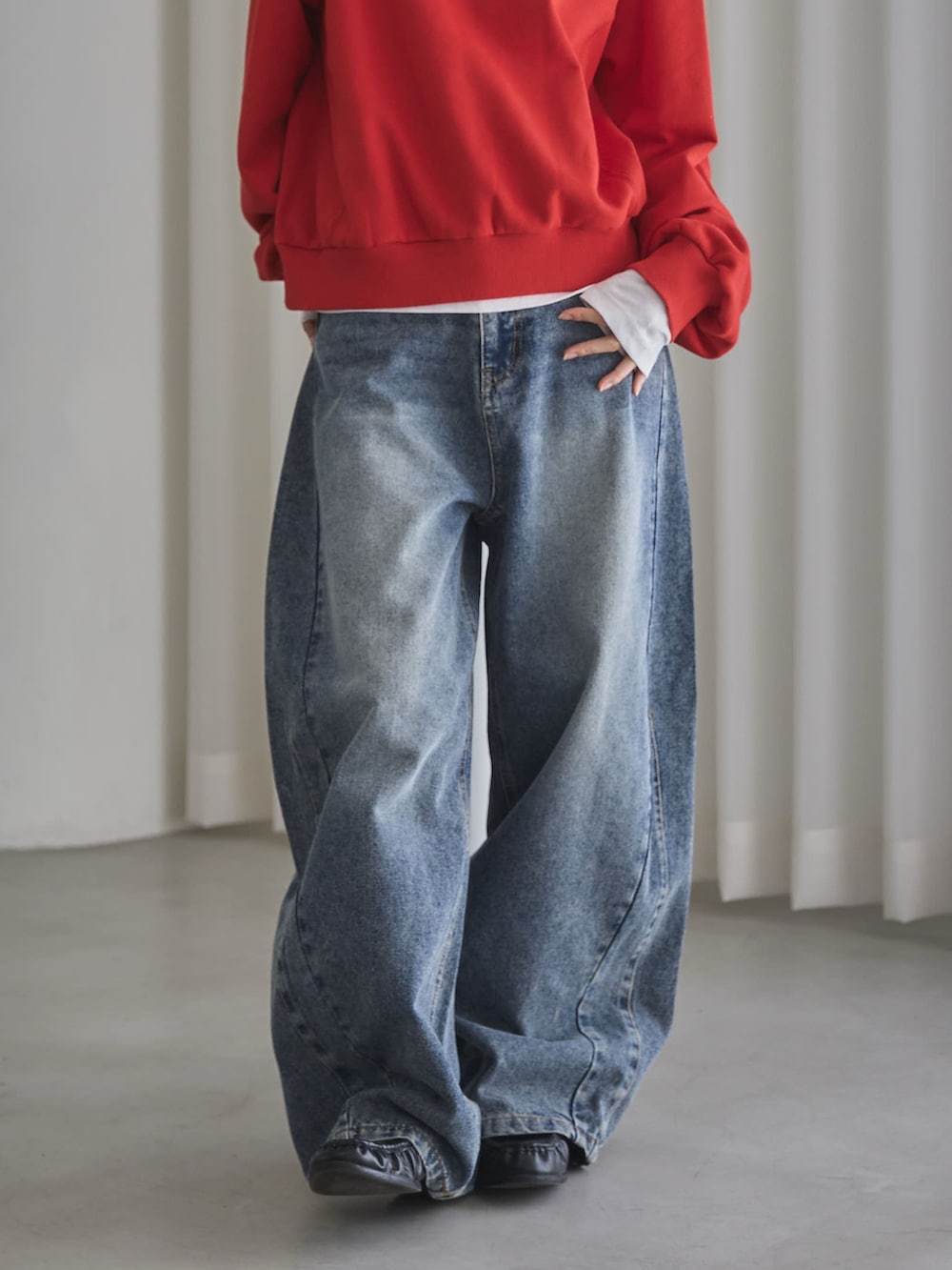 レッド系のスウェット、ホワイト系のTシャツ/カットソー、ブルー系のデニムパンツを着用したレディースの秋コーディネートの6枚目の写真