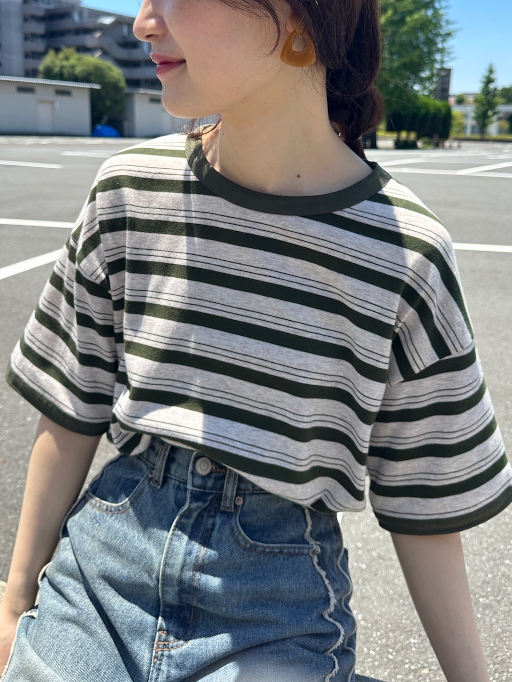 ブルー系のデニムスカート、グリーン系のTシャツ/カットソー、グレー系のスニーカーを着用したレディースの夏コーディネートの4枚目の写真
