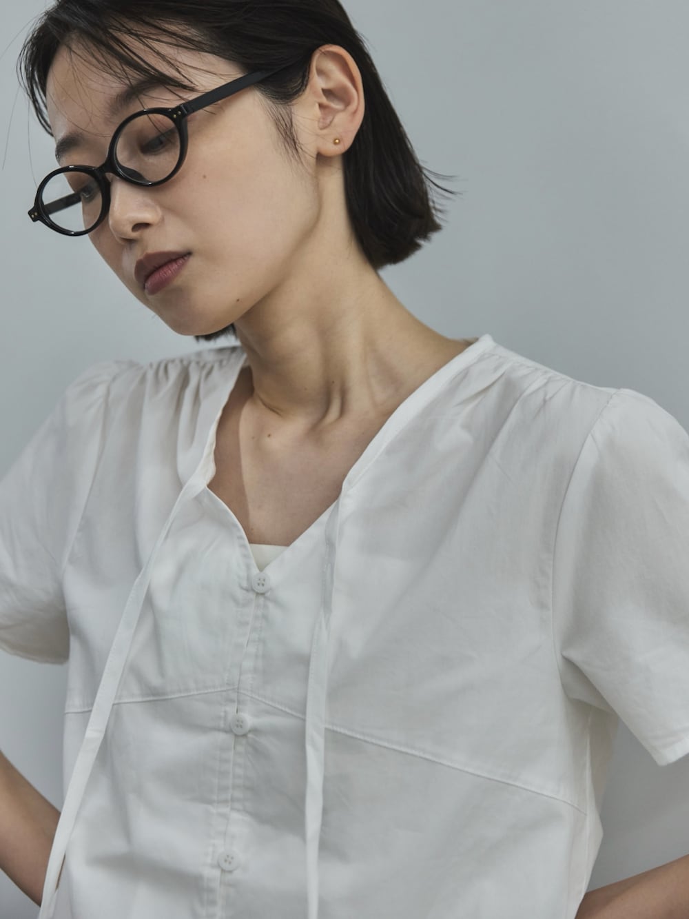 ホワイト系のシャツ/ブラウス、グレー系のスラックス、ブラック系のローファーを着用したレディースの夏コーディネートの4枚目の写真