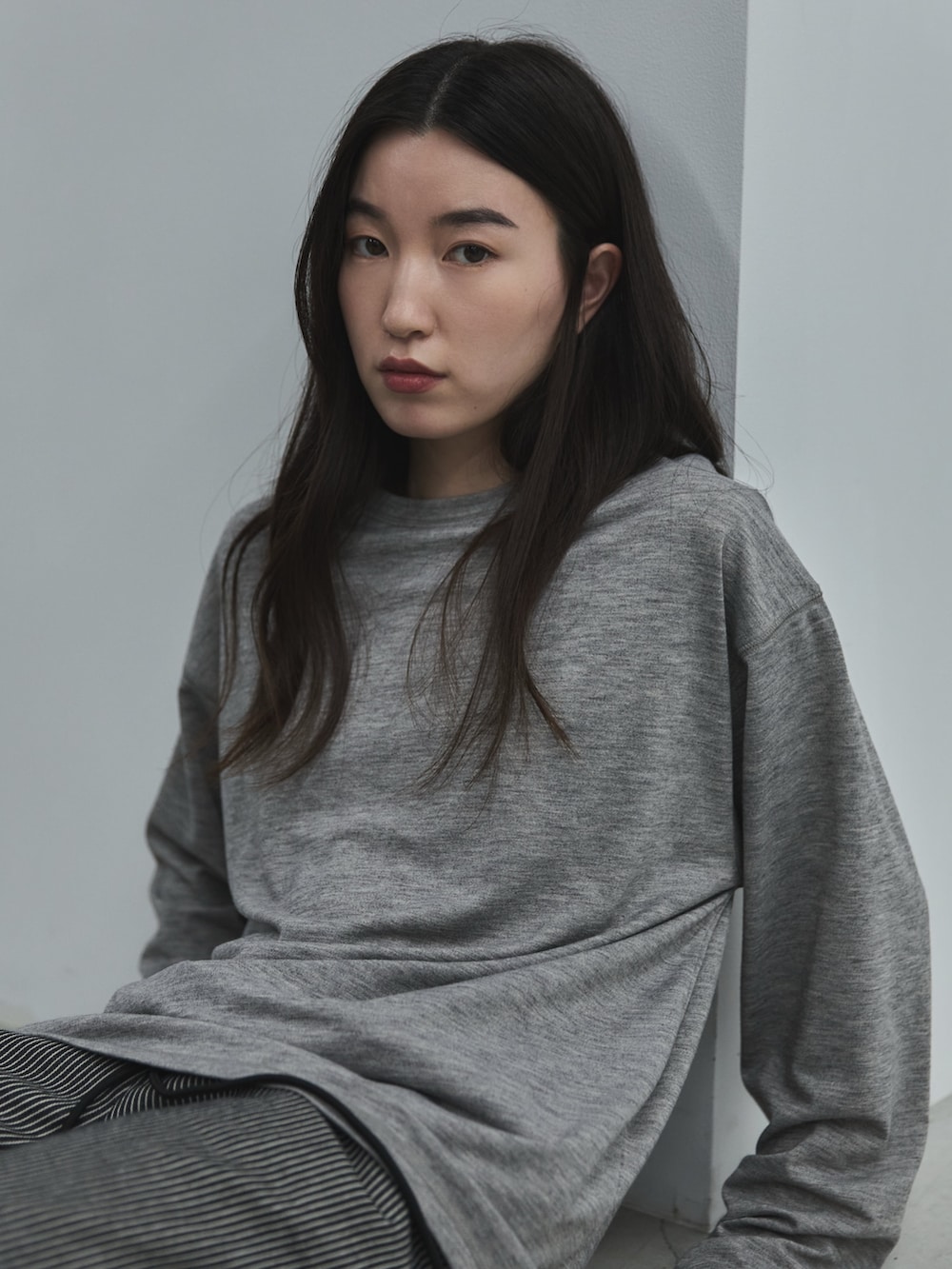 ブラック系のデニムパンツ、ブラック系のその他シューズ、グレー系のTシャツ/カットソーを着用したレディースの秋コーディネートの5枚目の写真