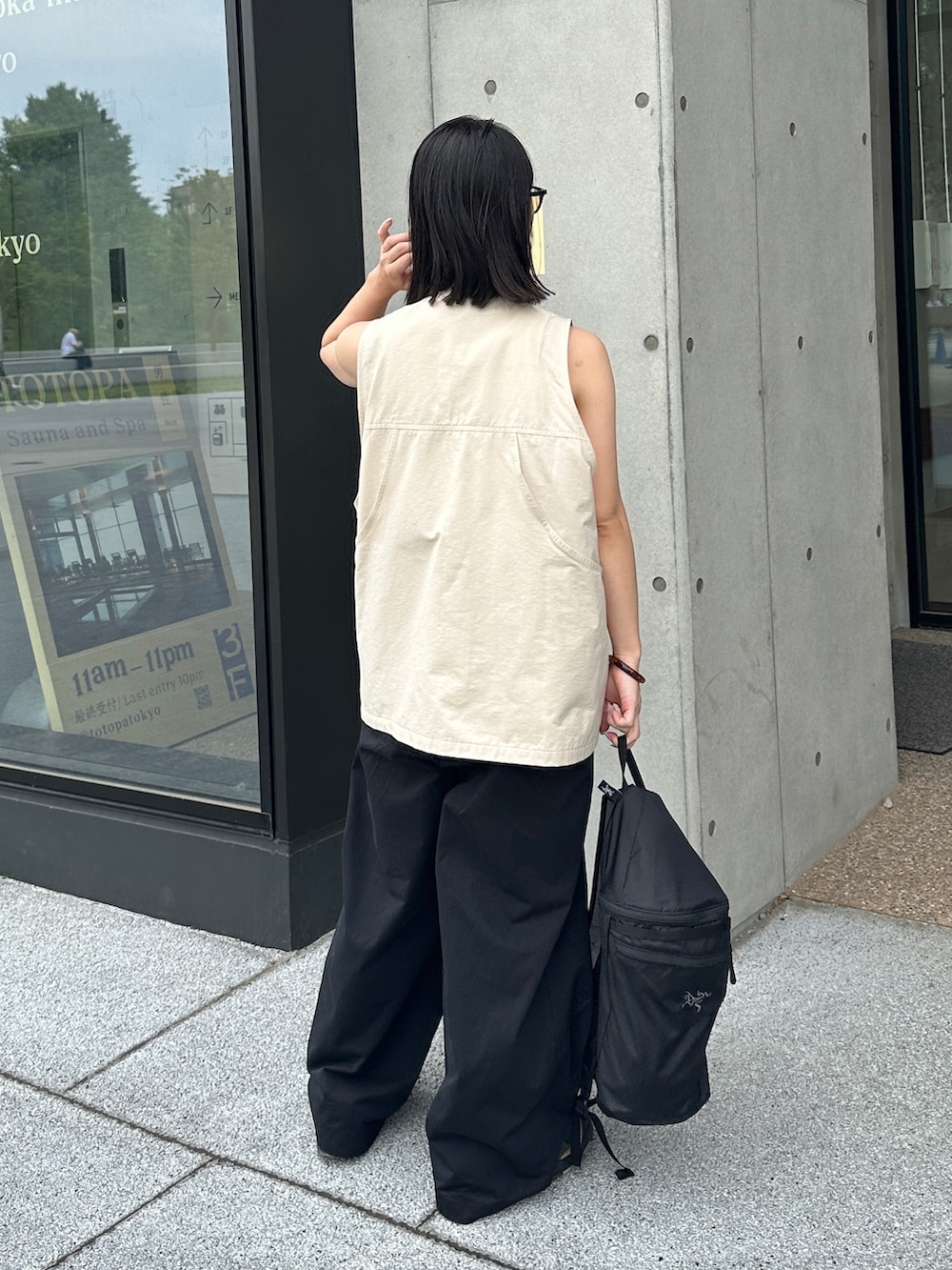 ホワイト系のベスト、ブラック系のその他パンツ、グリーン系のスニーカーを着用したレディースの夏コーディネートの3枚目の写真