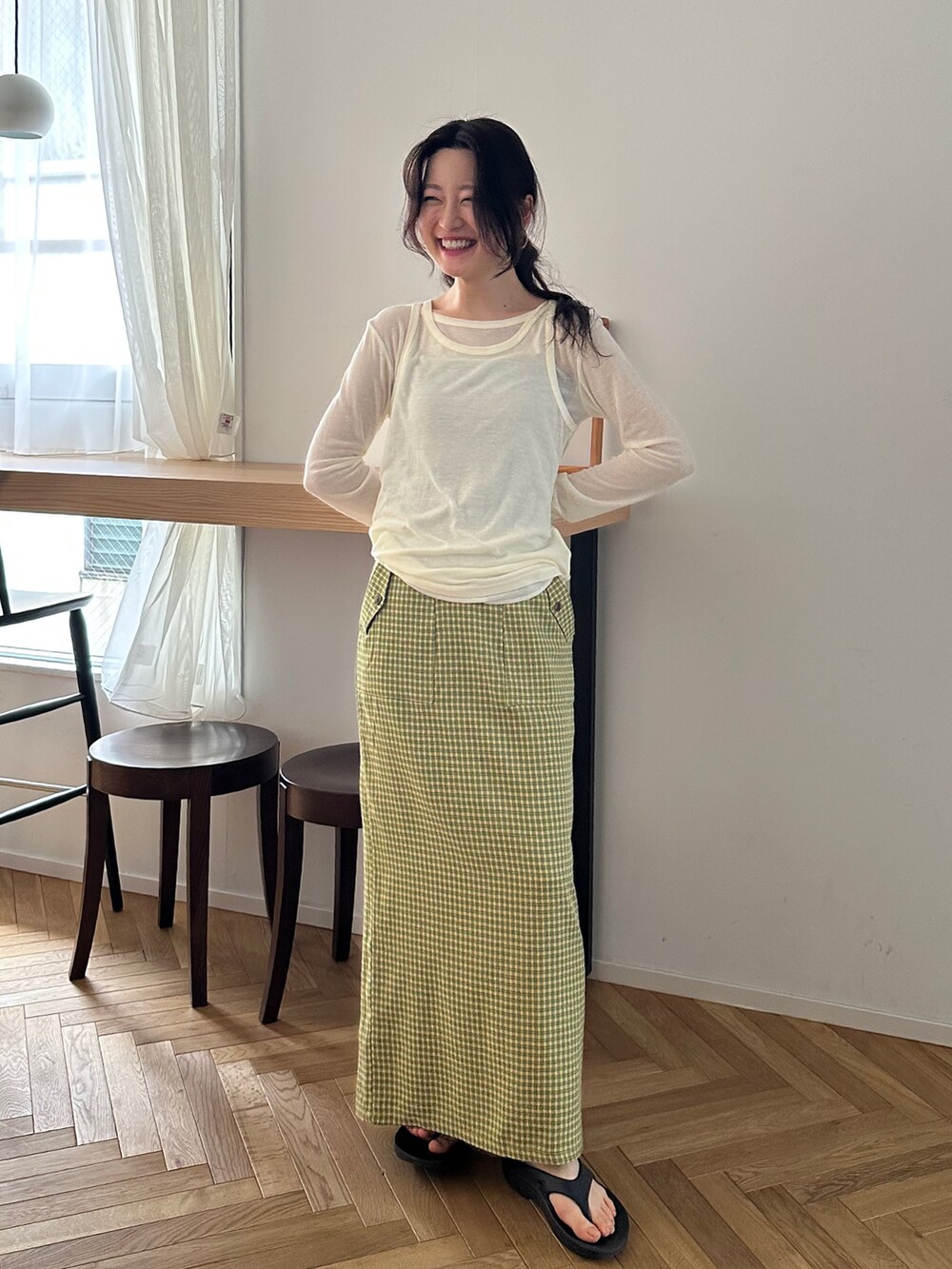 ホワイト系のTシャツ/カットソー、イエロー系のスカート、ブラック系のサンダルを着用したレディースの春コーディネートの5枚目の写真