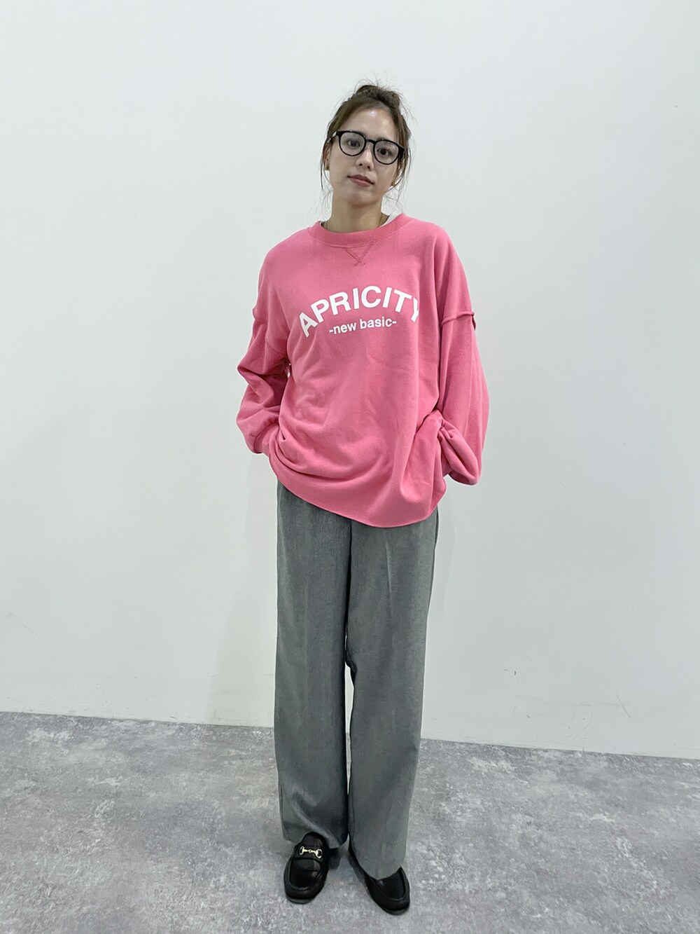 グレー系のスラックス、ピンク系のスウェット、ピンク系のスウェットを着用したレディースの秋コーディネートの3枚目の写真