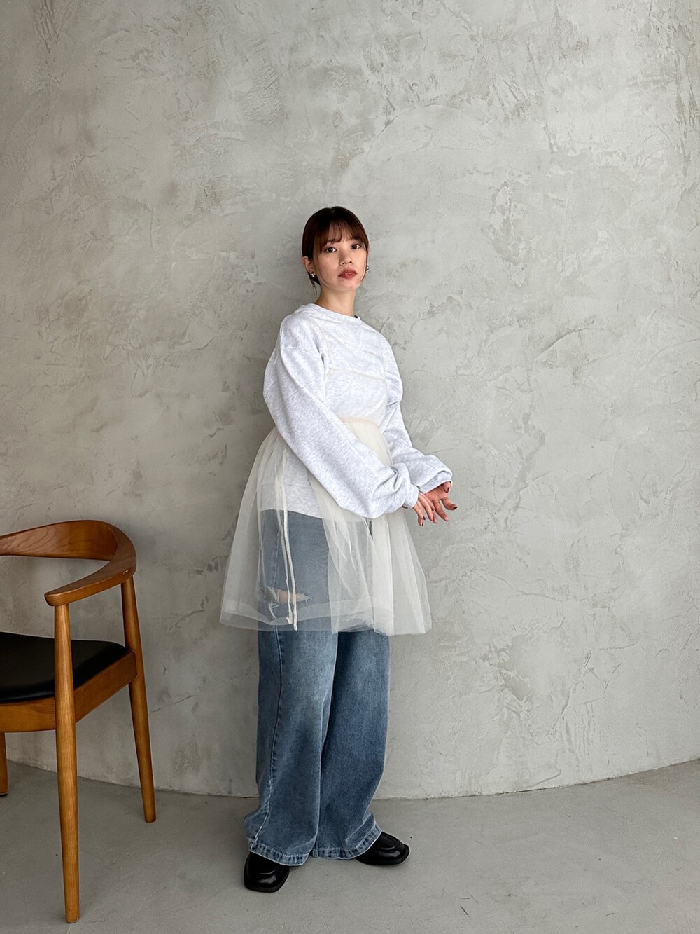 ベージュ系のスウェット、ホワイト系のシャツ/ブラウス、ブルー系のデニムパンツを着用したレディースの冬コーディネートの2枚目の写真