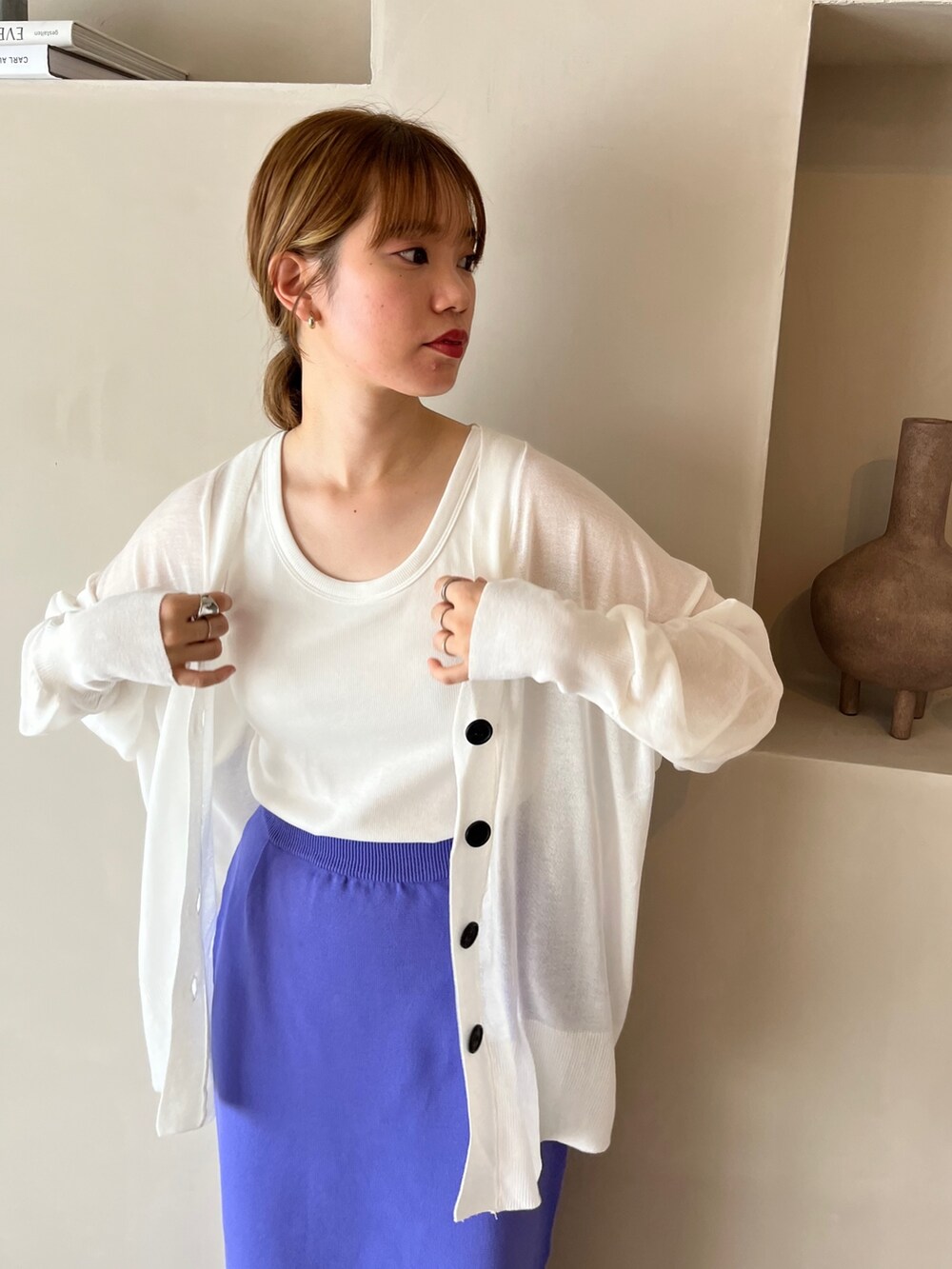 パープル系のスカート、ホワイト系のスニーカー、ホワイト系のタンクトップを着用したレディースの春コーディネートの2枚目の写真