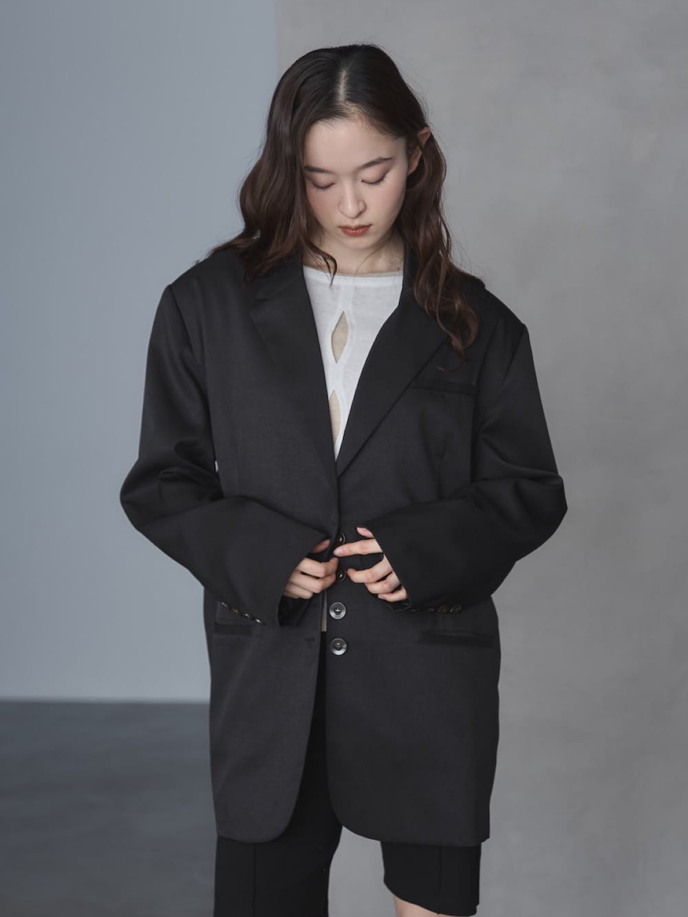 ブラック系のテーラードジャケット、ホワイト系のTシャツ/カットソー、ブラック系のその他パンツを着用したレディースの春コーディネートの4枚目の写真