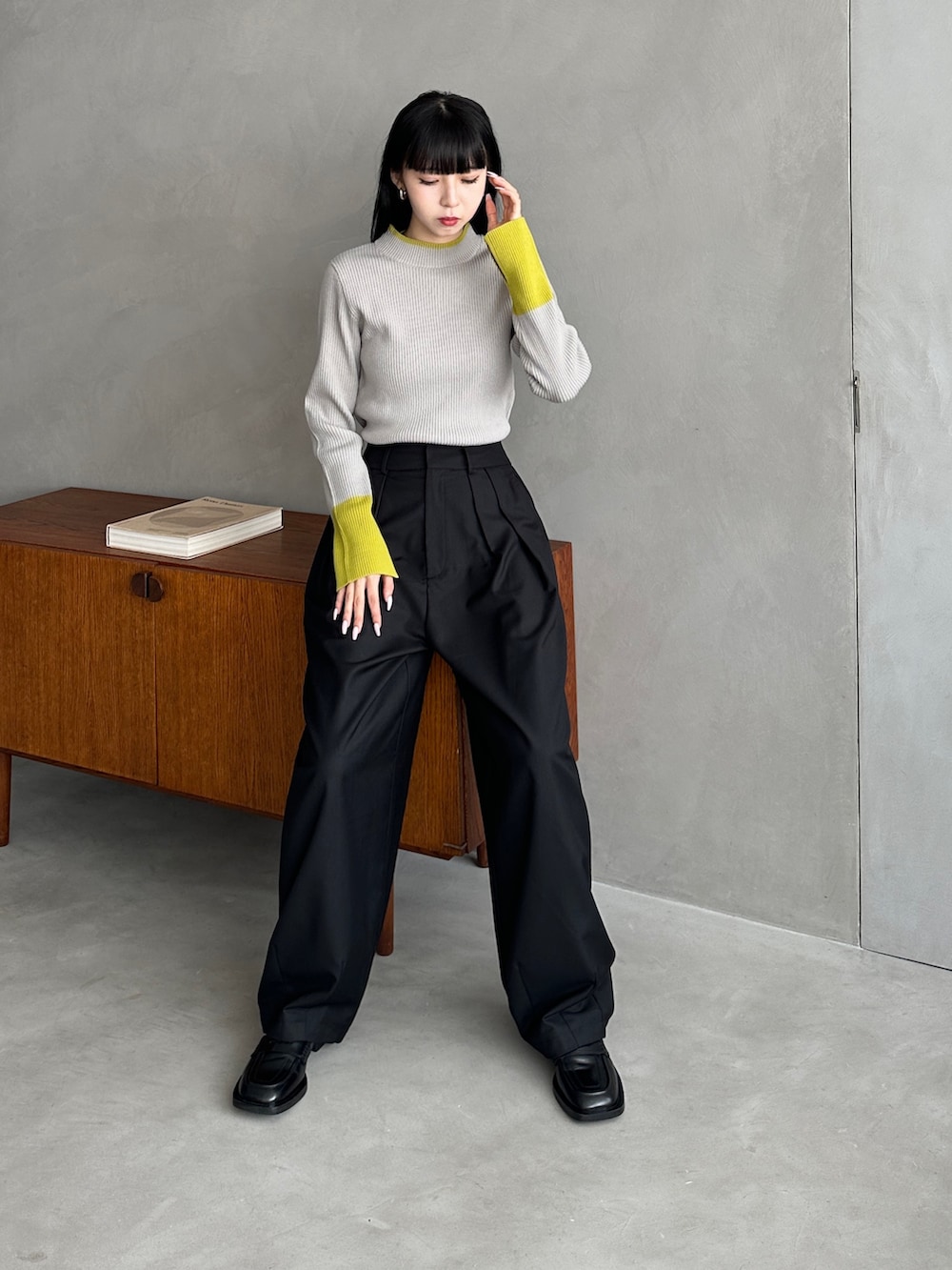 グレー系のニット/セーター、ブラック系のパンツを着用したレディースの秋コーディネートの3枚目の写真