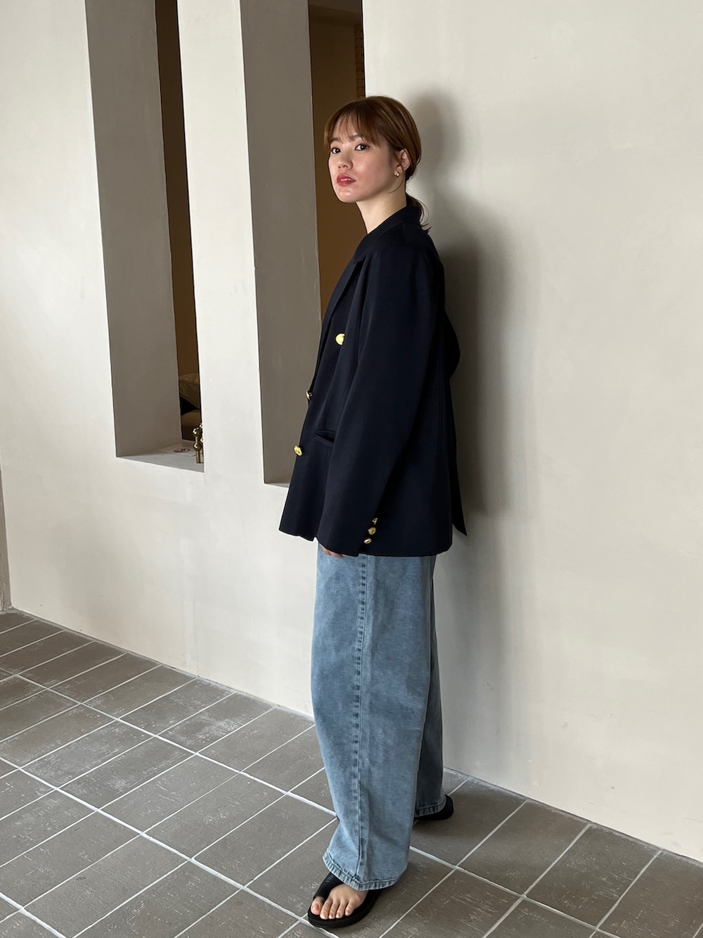 ブルー系のテーラードジャケット、ベージュ系のタンクトップ、グレー系のスラックスを着用したレディースの春コーディネートの2枚目の写真