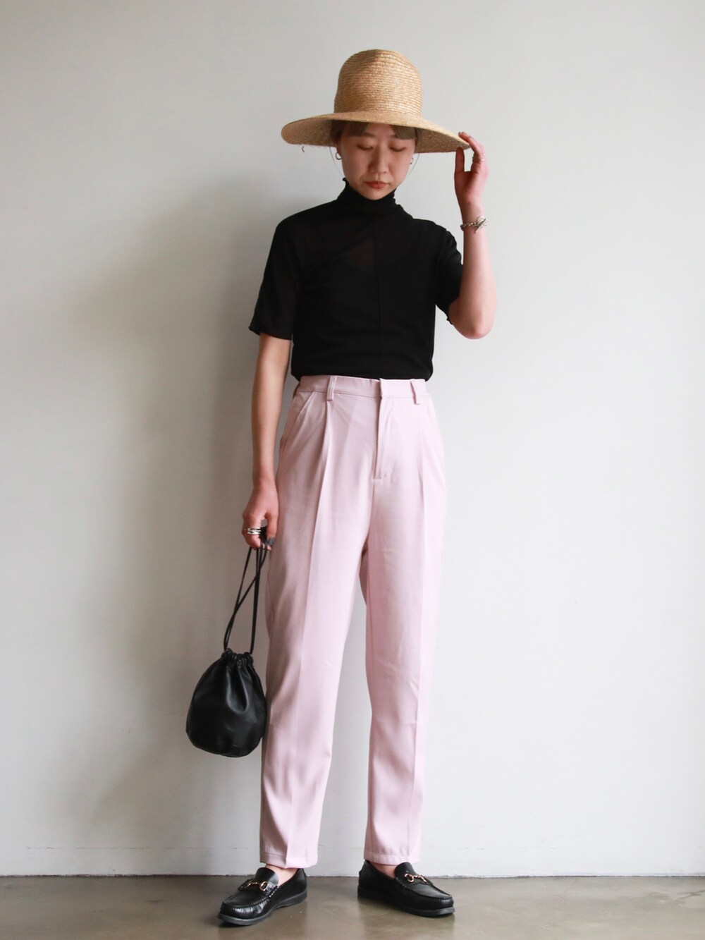 ピンク系のスラックス、ブラック系のニット/セーター、パープル系のスラックスを着用したレディースの春コーディネートの3枚目の写真