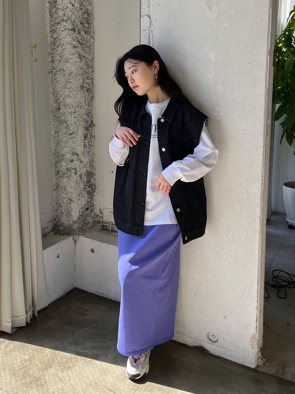 ブラック系のベスト、ホワイト系のスウェット、パープル系のスカートを着用したレディースの春コーディネートの3枚目の写真
