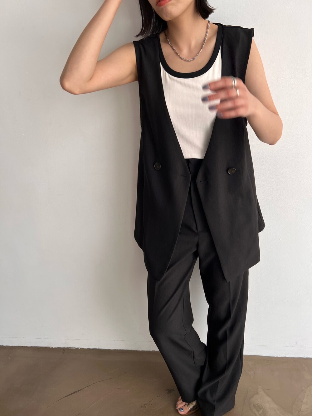 ホワイト系のタンクトップ、ブラック系のセットアップ、その他のサンダルを着用したレディースの春コーディネートの3枚目の写真