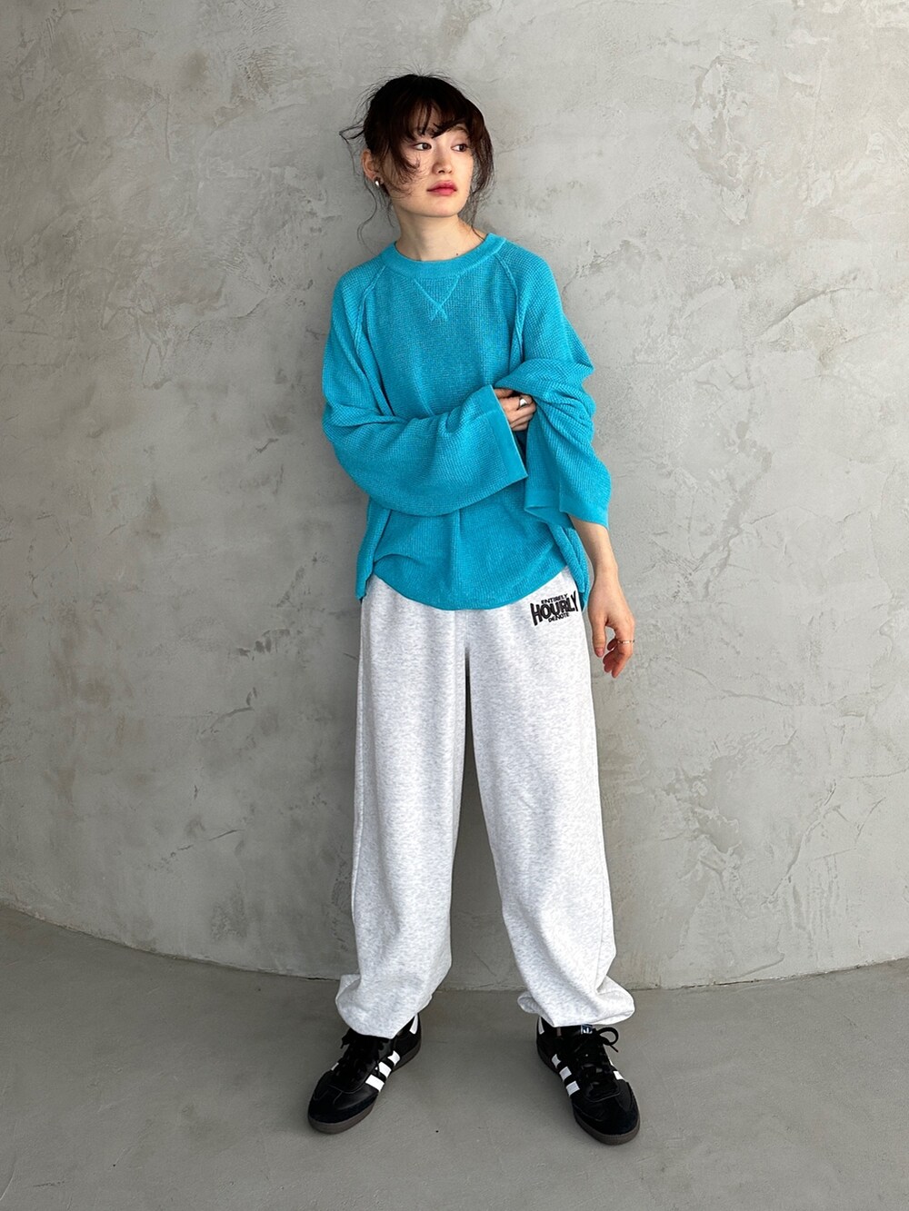 ブルー系のニット/セーター、ベージュ系のスウェットパンツ、ブラック系のスニーカーを着用したレディースの冬コーディネートの2枚目の写真