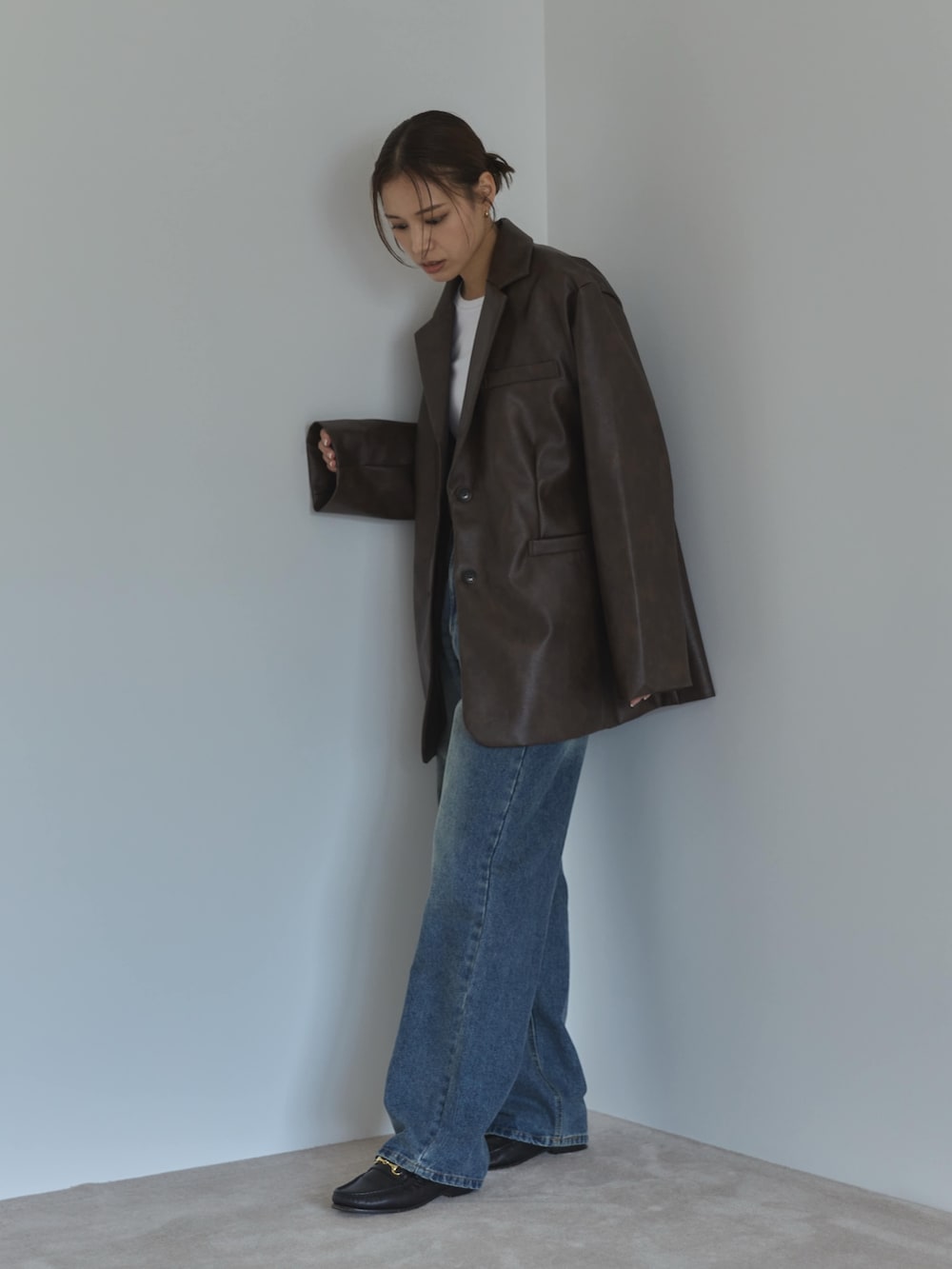 ブラウン系のテーラードジャケット、ホワイト系のTシャツ/カットソー、ブルー系のデニムパンツを着用したレディースの夏コーディネートの3枚目の写真