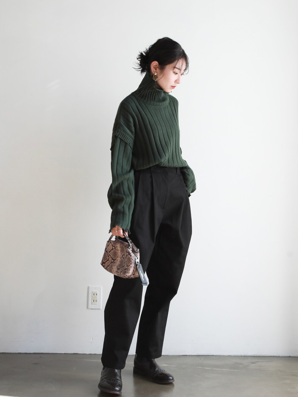 グリーン系のニット/セーター、その他のショルダーバッグ、ブラック系のチノパンツを着用したレディースの冬コーディネートの2枚目の写真