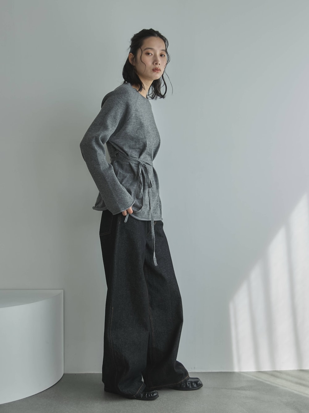 グレー系のニット/セーター、ブラック系のデニムパンツ、その他のその他を着用したレディースの秋コーディネートの4枚目の写真