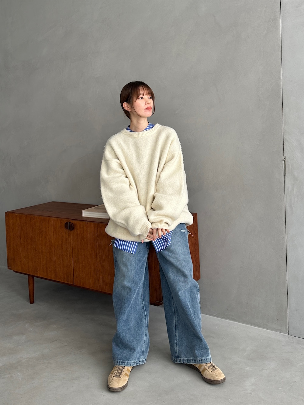 ホワイト系のニット/セーター、ブルー系のシャツ/ブラウス、ブルー系のデニムパンツを着用したレディースの冬コーディネートの4枚目の写真