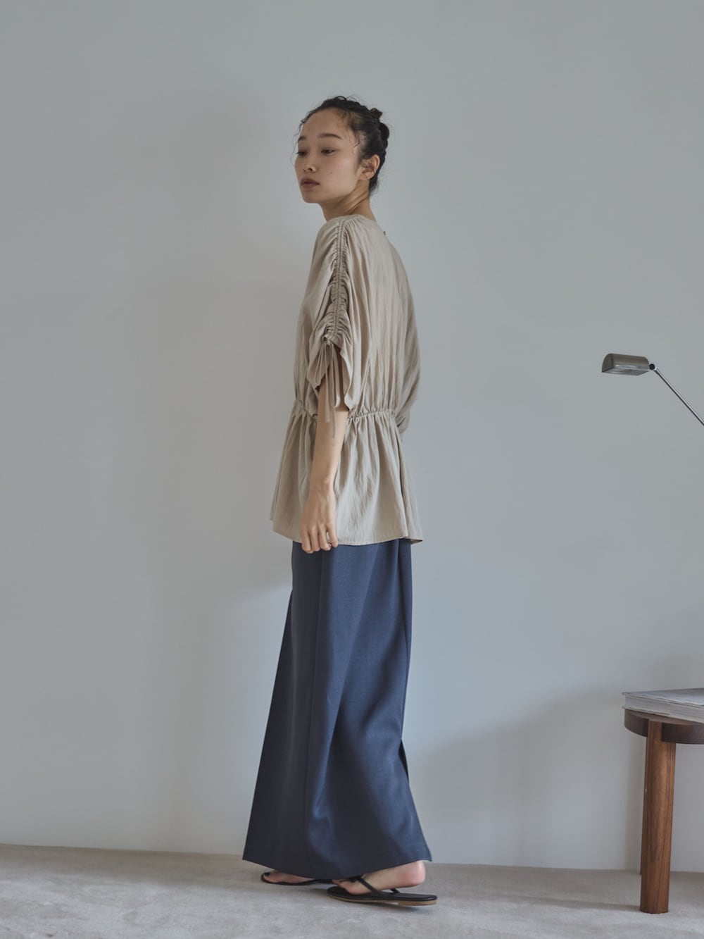 ホワイト系のシャツ/ブラウス、グレー系のスカート、ブラック系のサンダルを着用したレディースの夏コーディネートの3枚目の写真