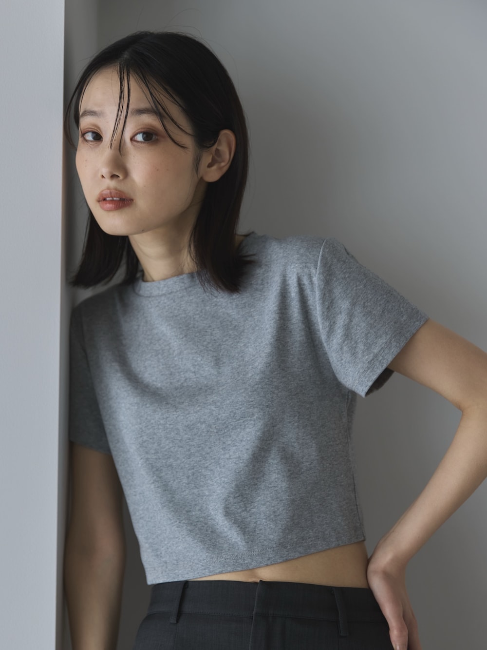 グレー系のTシャツ/カットソー、グレー系のスカート、ブラック系のサンダルを着用したレディースの夏コーディネートの5枚目の写真