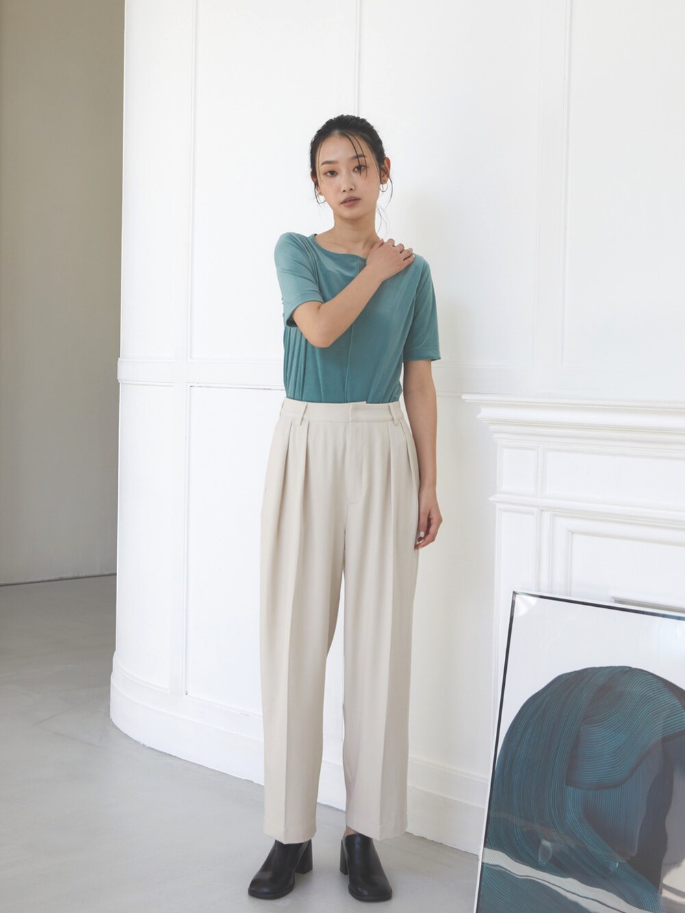 ホワイト系のスラックス、グリーン系のTシャツ/カットソー、ブラック系のスリッポンを着用したレディースの夏コーディネートの2枚目の写真