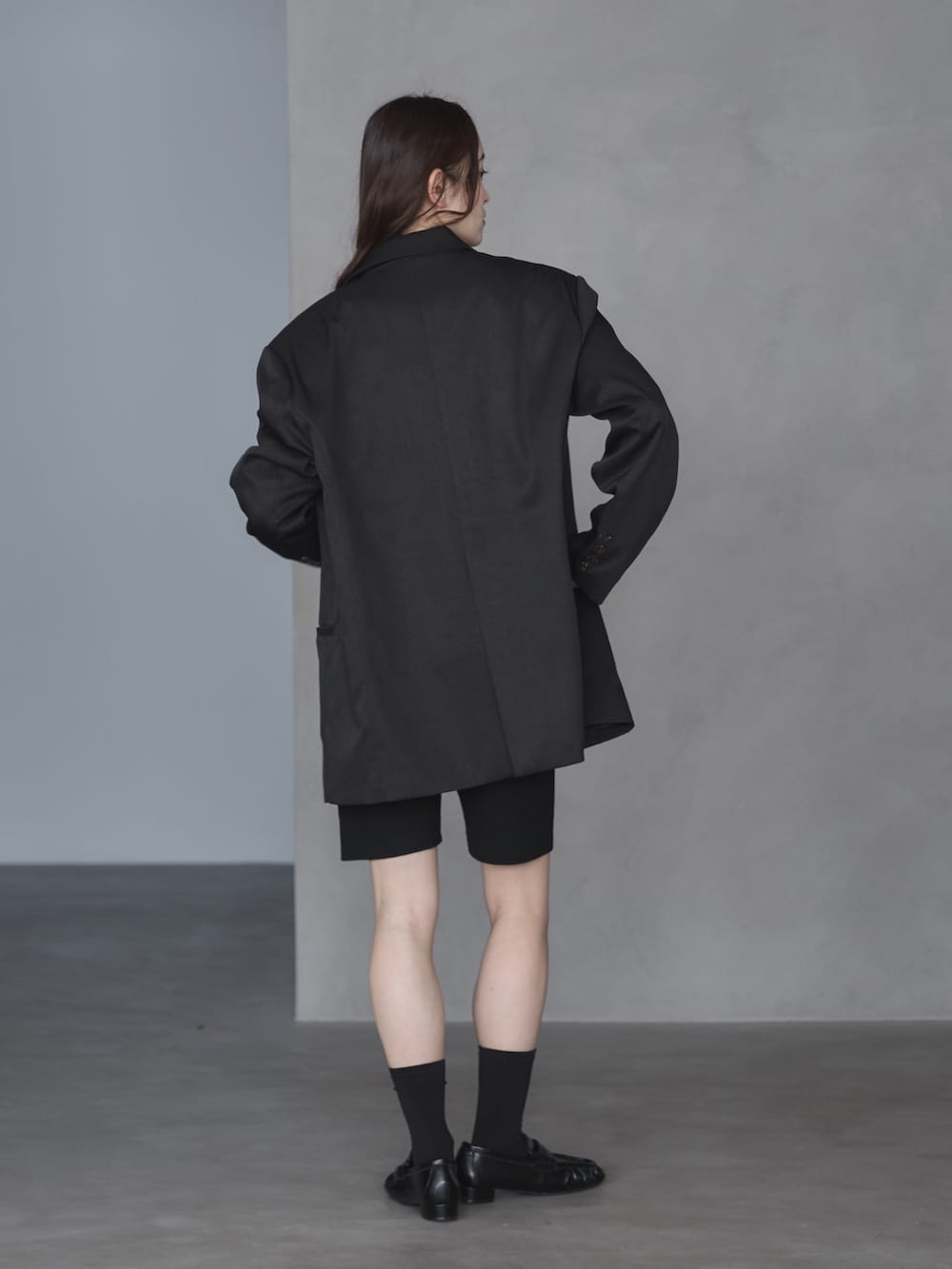 ブラック系のテーラードジャケット、ホワイト系のTシャツ/カットソー、ブラック系のその他パンツを着用したレディースの春コーディネートの3枚目の写真