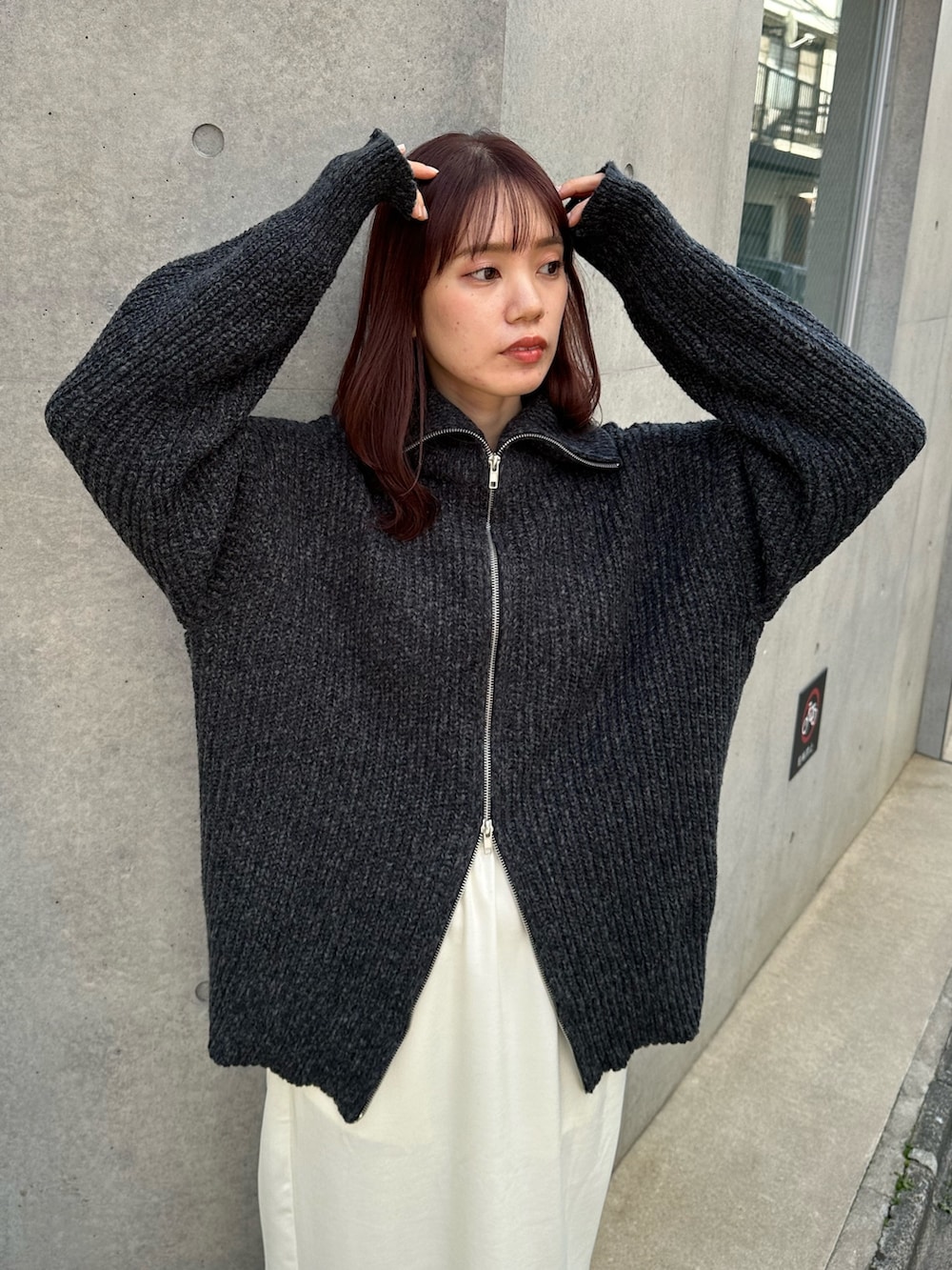 ブラック系のカーディガン/ボレロ、ホワイト系のスカート、グレー系のスニーカーを着用したレディースの冬コーディネートの3枚目の写真