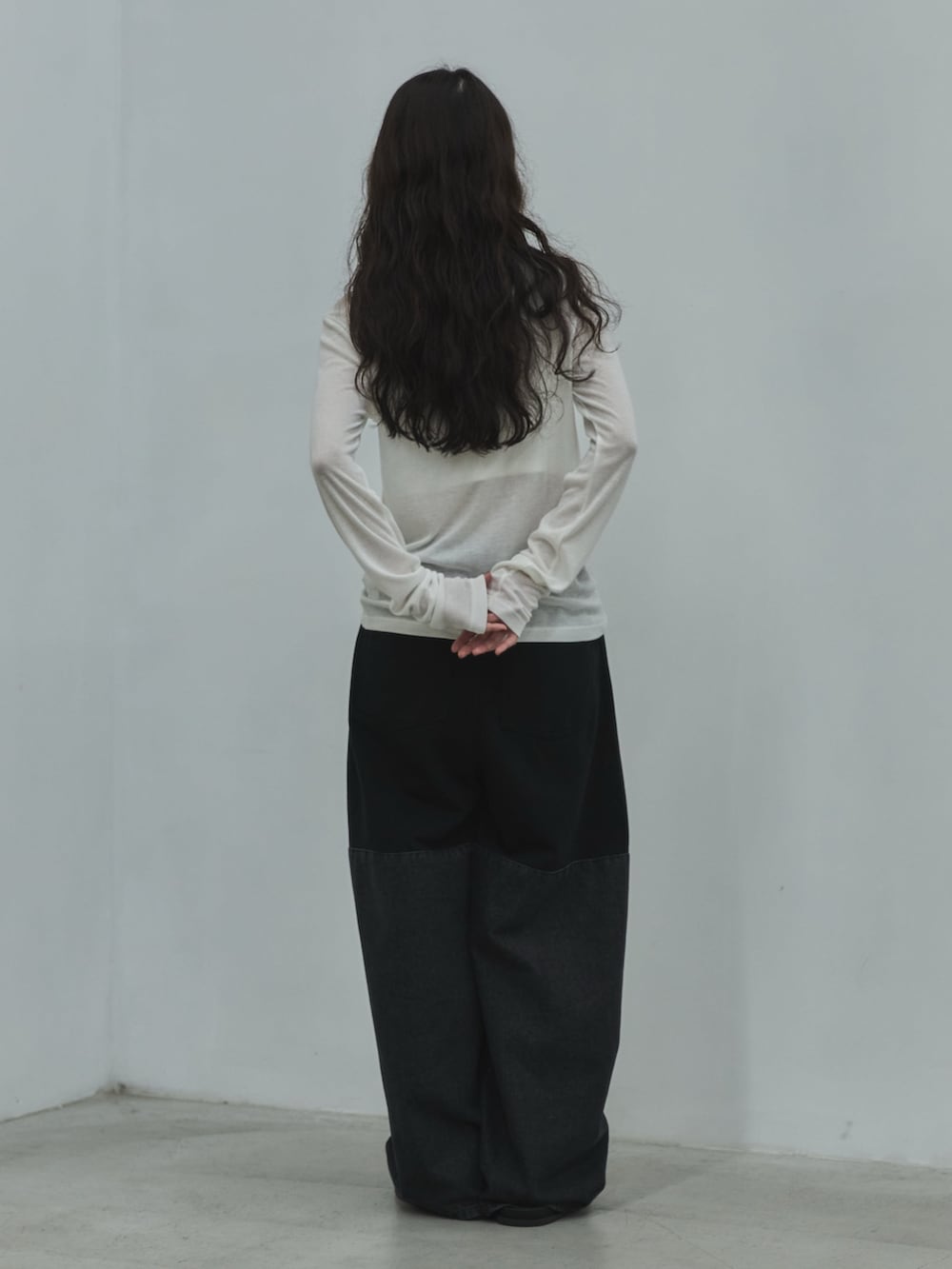 ホワイト系のキャミソール、ホワイト系のTシャツ/カットソー、ブラック系のデニムパンツを着用したレディースの秋コーディネートの3枚目の写真
