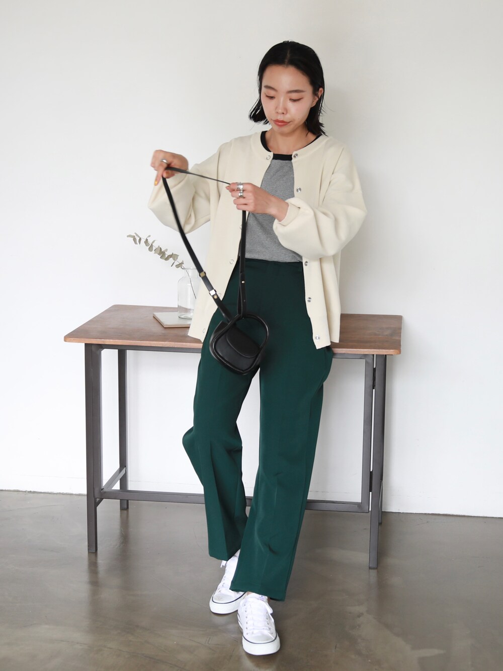 ホワイト系のスニーカー、ホワイト系のカーディガン/ボレロ、ブラック系のTシャツ/カットソーを着用したレディースの夏コーディネートの2枚目の写真