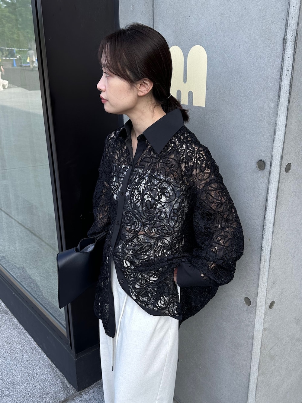 ブラック系のシャツ/ブラウス、ブラック系のショルダーバッグ、ホワイト系のその他パンツを着用したレディースの春コーディネートの3枚目の写真