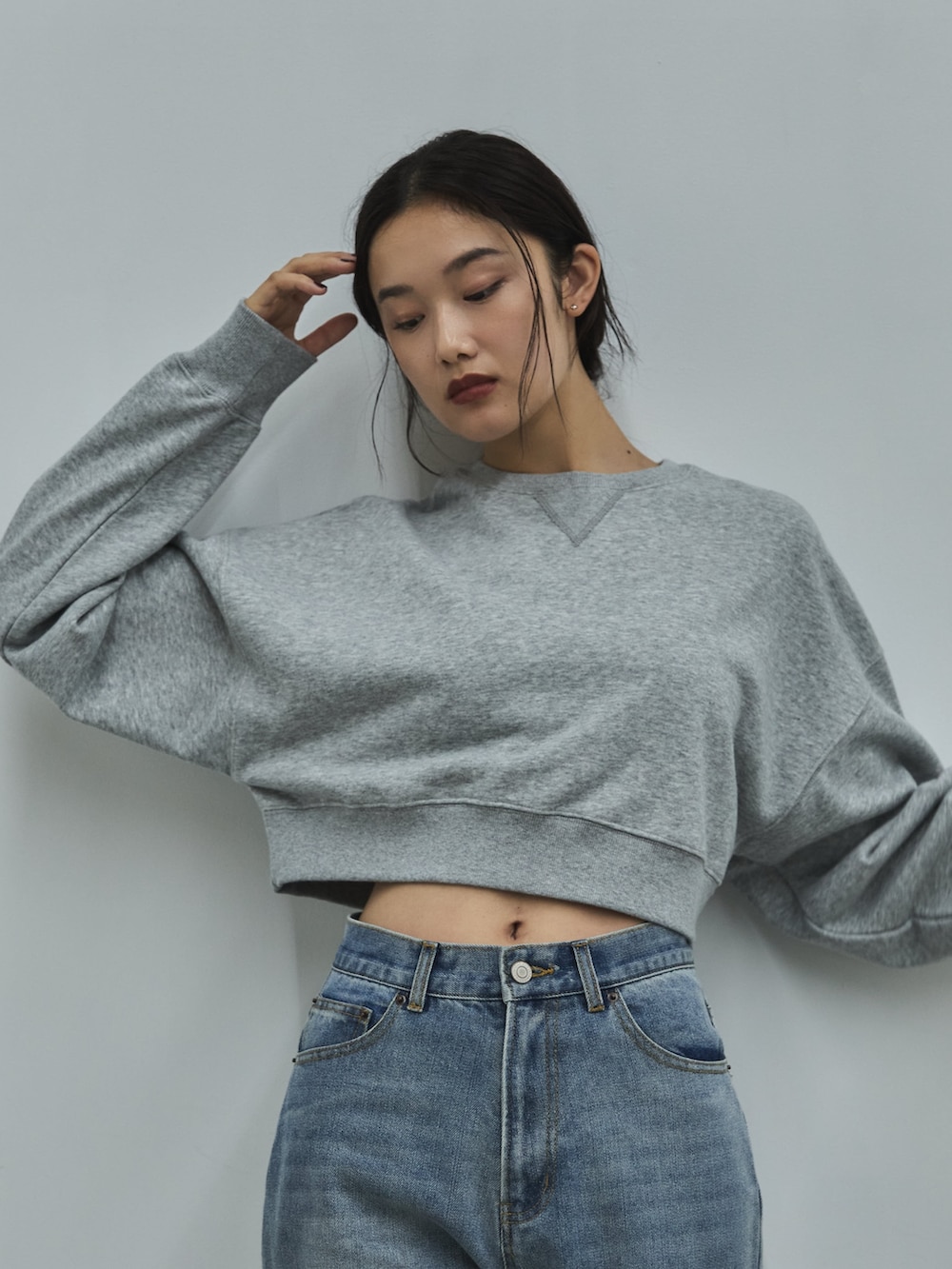 グレー系のスウェット、ブルー系のデニムパンツ、ベージュ系のその他シューズを着用したレディースの秋コーディネートの4枚目の写真