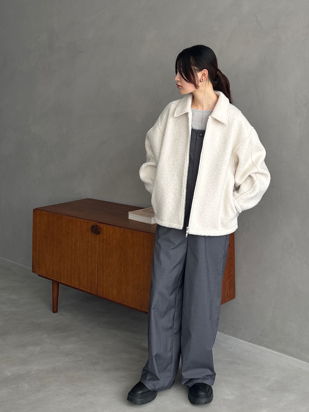 ホワイト系のブルゾン、シルバー系のTシャツ/カットソー、グレー系のサロペット/オーバーオールを着用したレディースの秋コーディネートの3枚目の写真