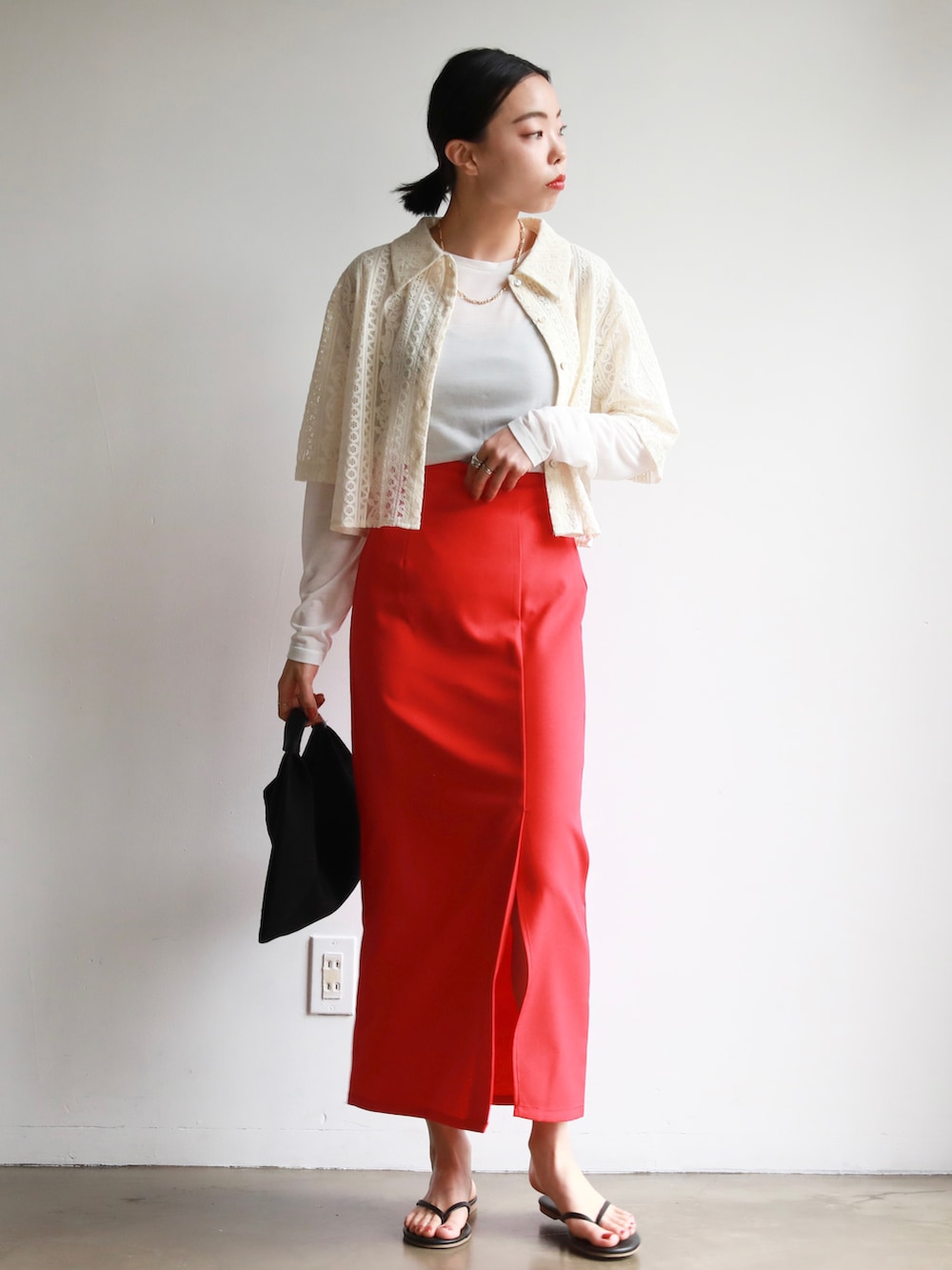 ブラック系のハンドバッグ、レッド系のスカート、ホワイト系のTシャツ/カットソーを着用したレディースの春コーディネートの3枚目の写真
