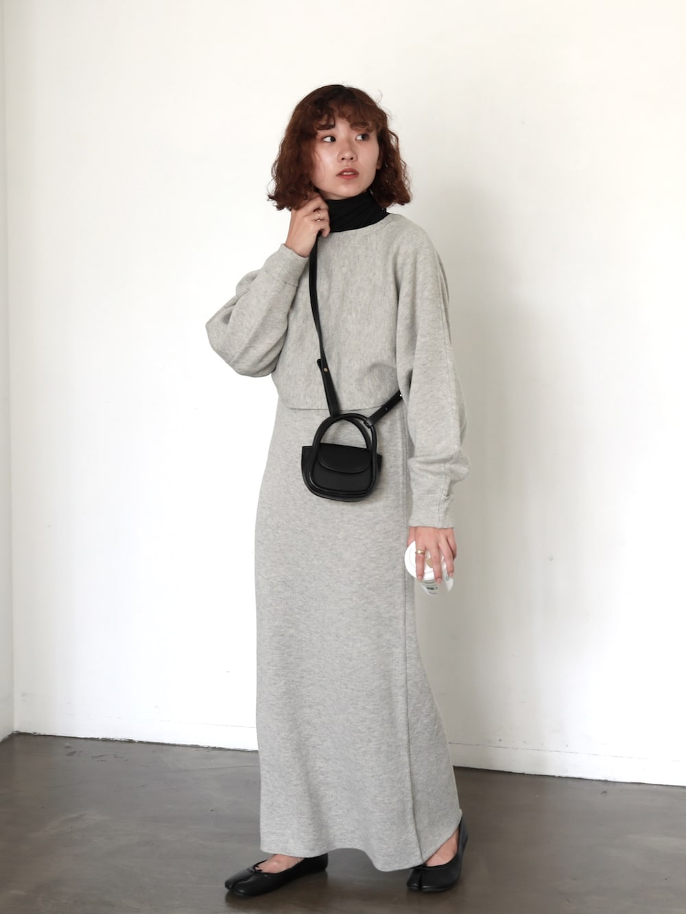 ブラック系のハンドバッグ、グレー系のワンピース、ブラック系のTシャツ/カットソーを着用したレディースの秋コーディネートの3枚目の写真
