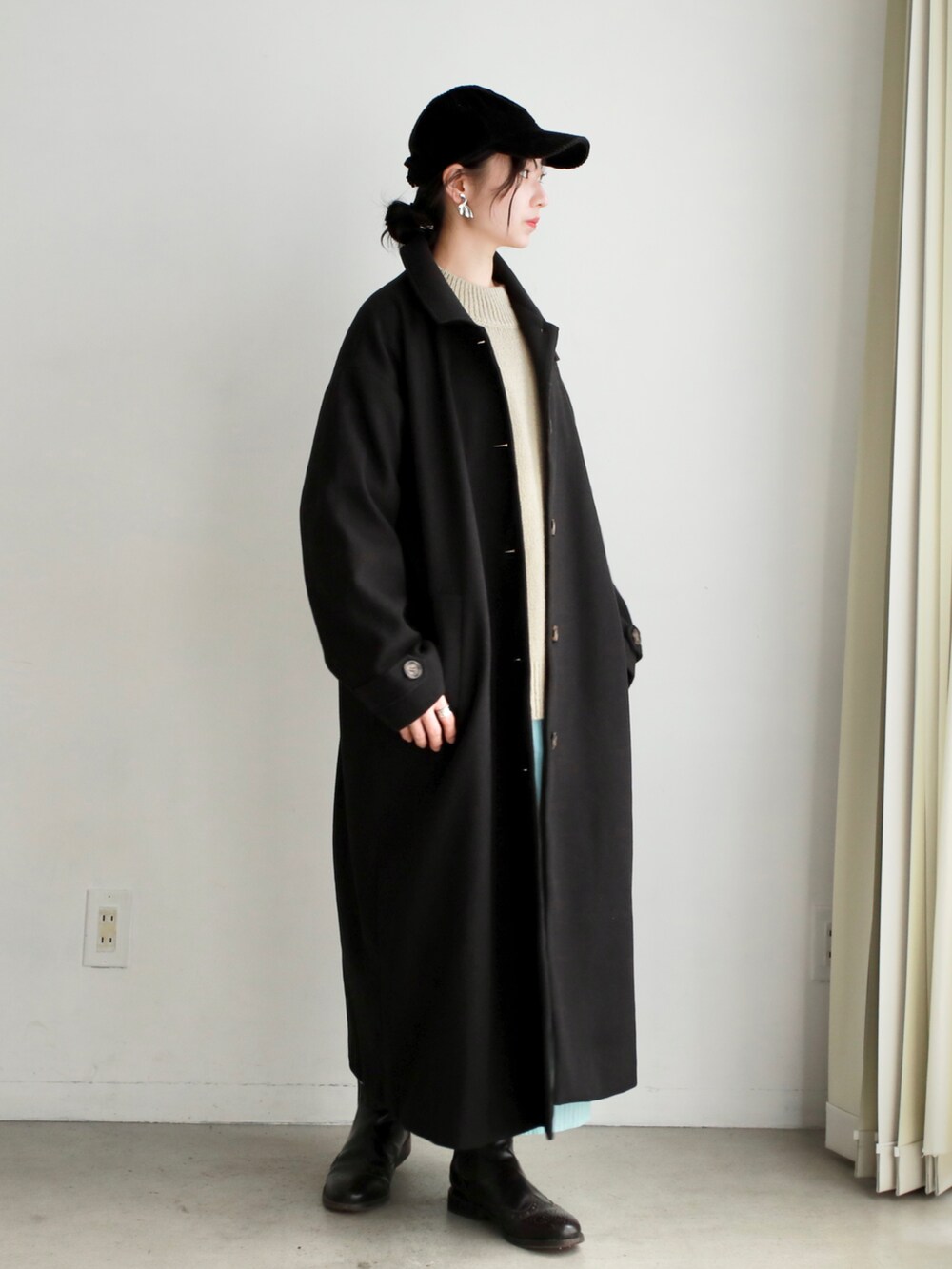 ホワイト系のニット/セーター、ブラック系のその他パンツ、ブラック系のハンドバッグを着用したレディースの冬コーディネートの3枚目の写真