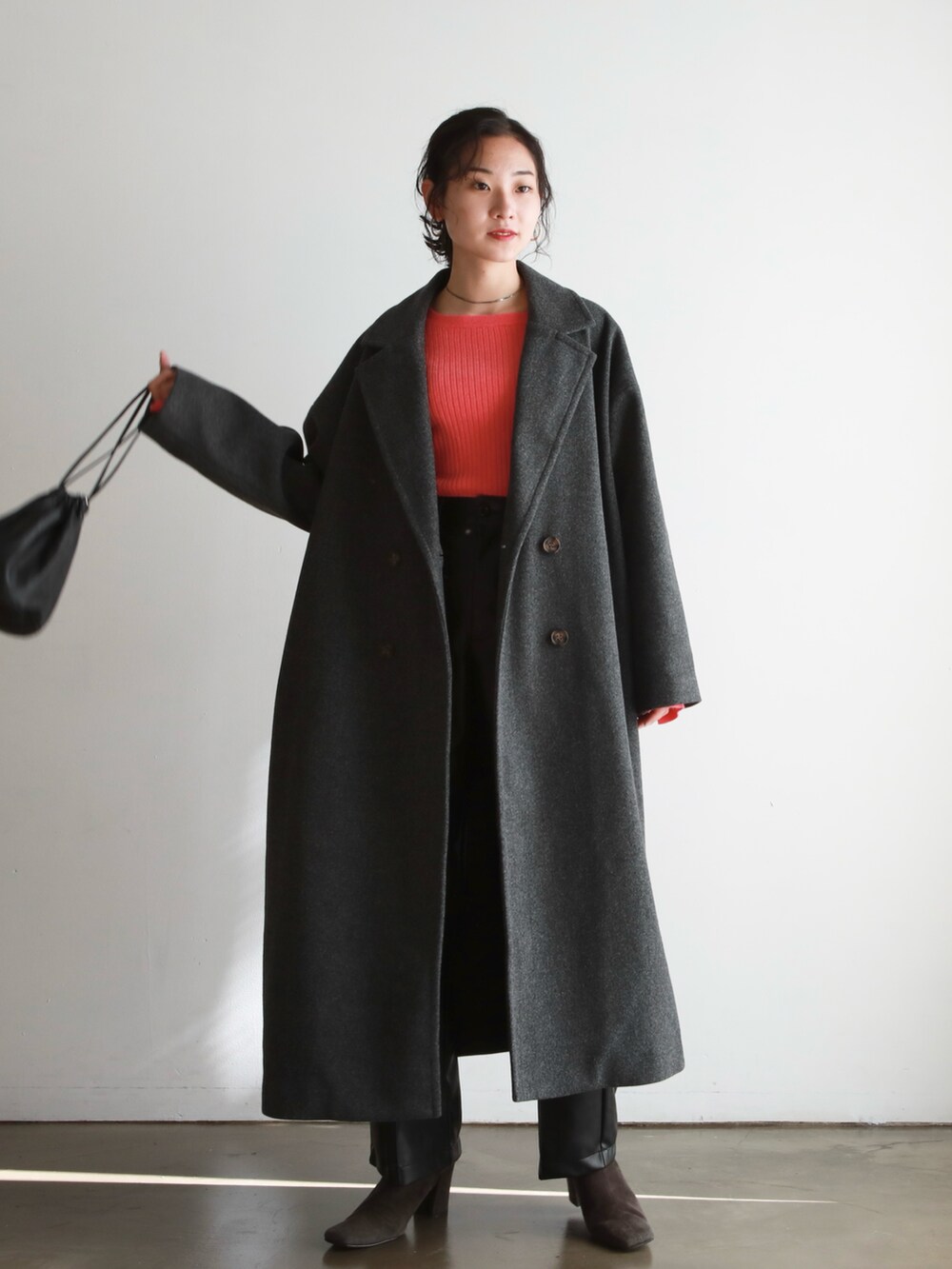 グレー系のチェスターコート、ピンク系のニット/セーター、グレー系のブーツを着用したレディースの秋コーディネートの2枚目の写真