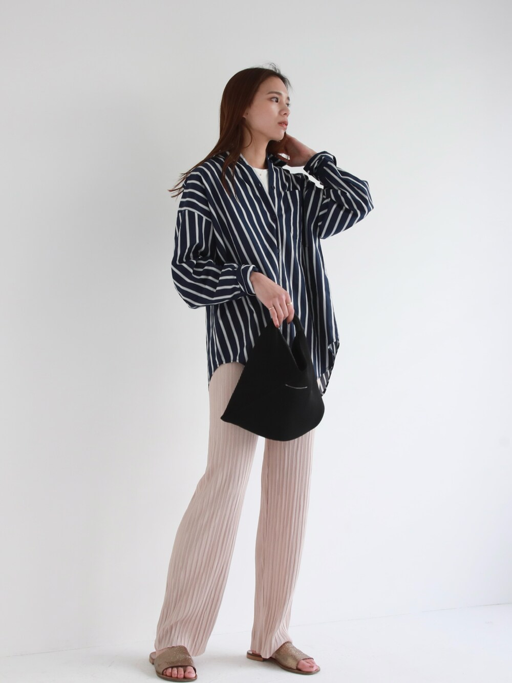 ブラック系のハンドバッグ、ブルー系のデニムパンツ、ピンク系のシャツ/ブラウスを着用したレディースの冬コーディネートの3枚目の写真