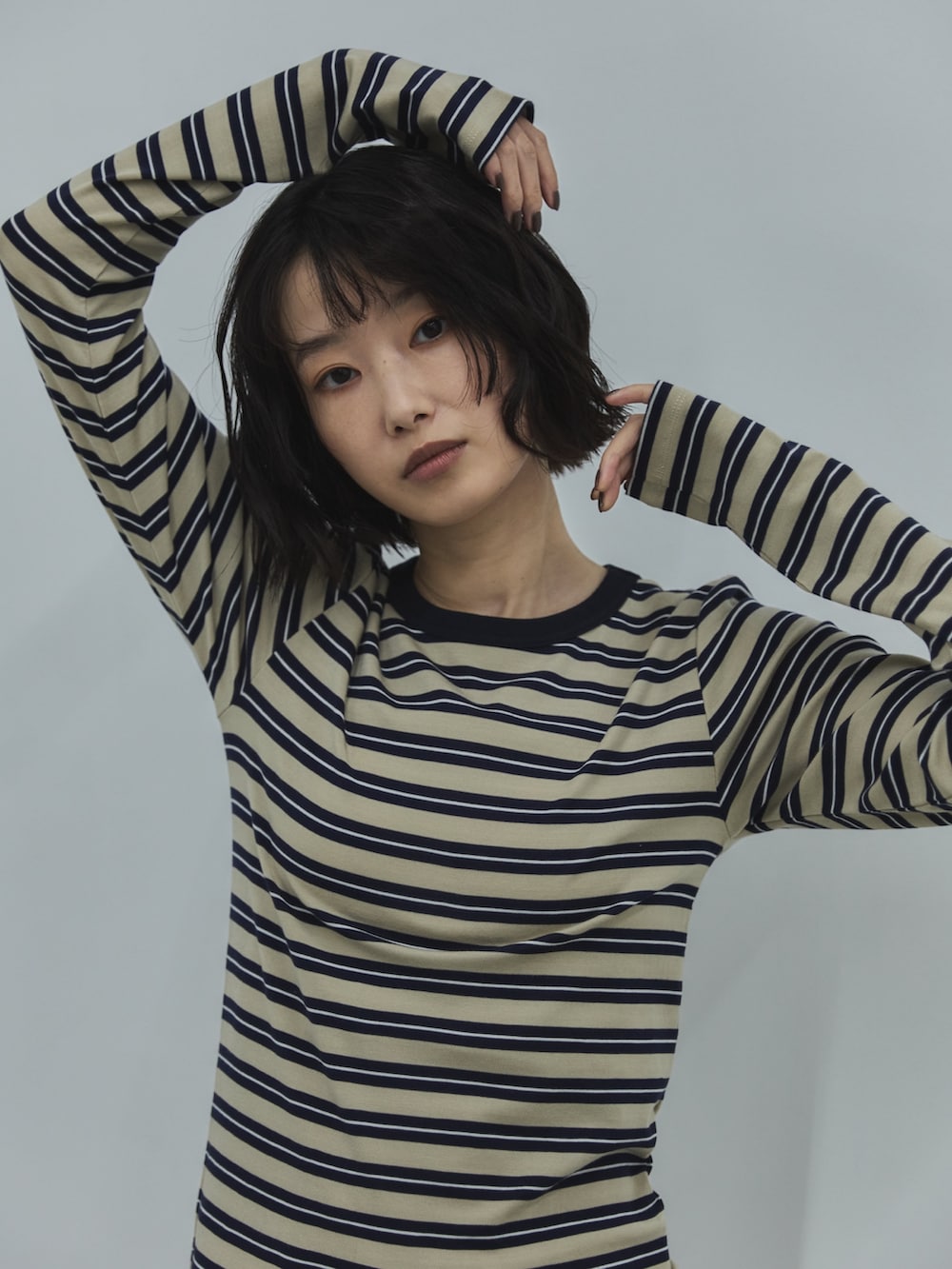 ベージュ系のTシャツ/カットソー、ホワイト系のデニムパンツ、ブラック系のローファーを着用したレディースの秋コーディネートの5枚目の写真