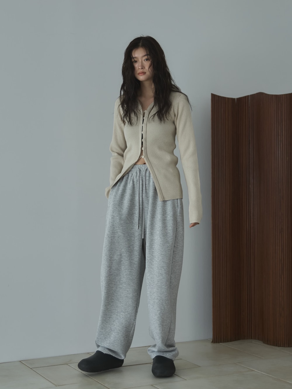 ホワイト系のカーディガン/ボレロ、グレー系のその他パンツ、ブラック系のサンダルを着用したレディースの秋コーディネートの3枚目の写真